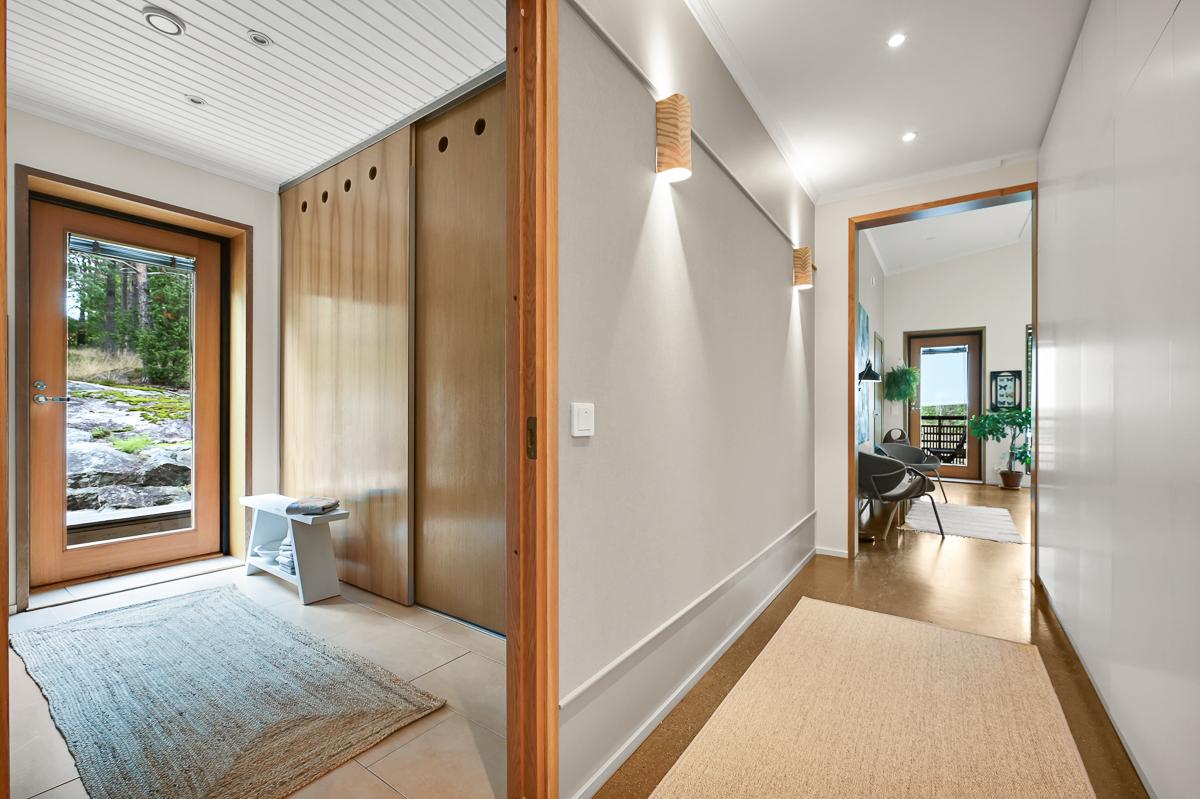 Liukuovien takana kodinhoitotila (pesuallas, kaapisto, pesutorni) vastapäätä  sauna ja suihkutila