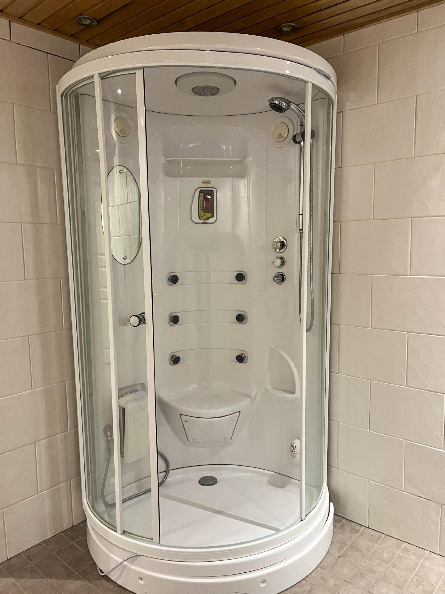 Kylpyhuoneessa kaksi suihkua ja suihkukaappi