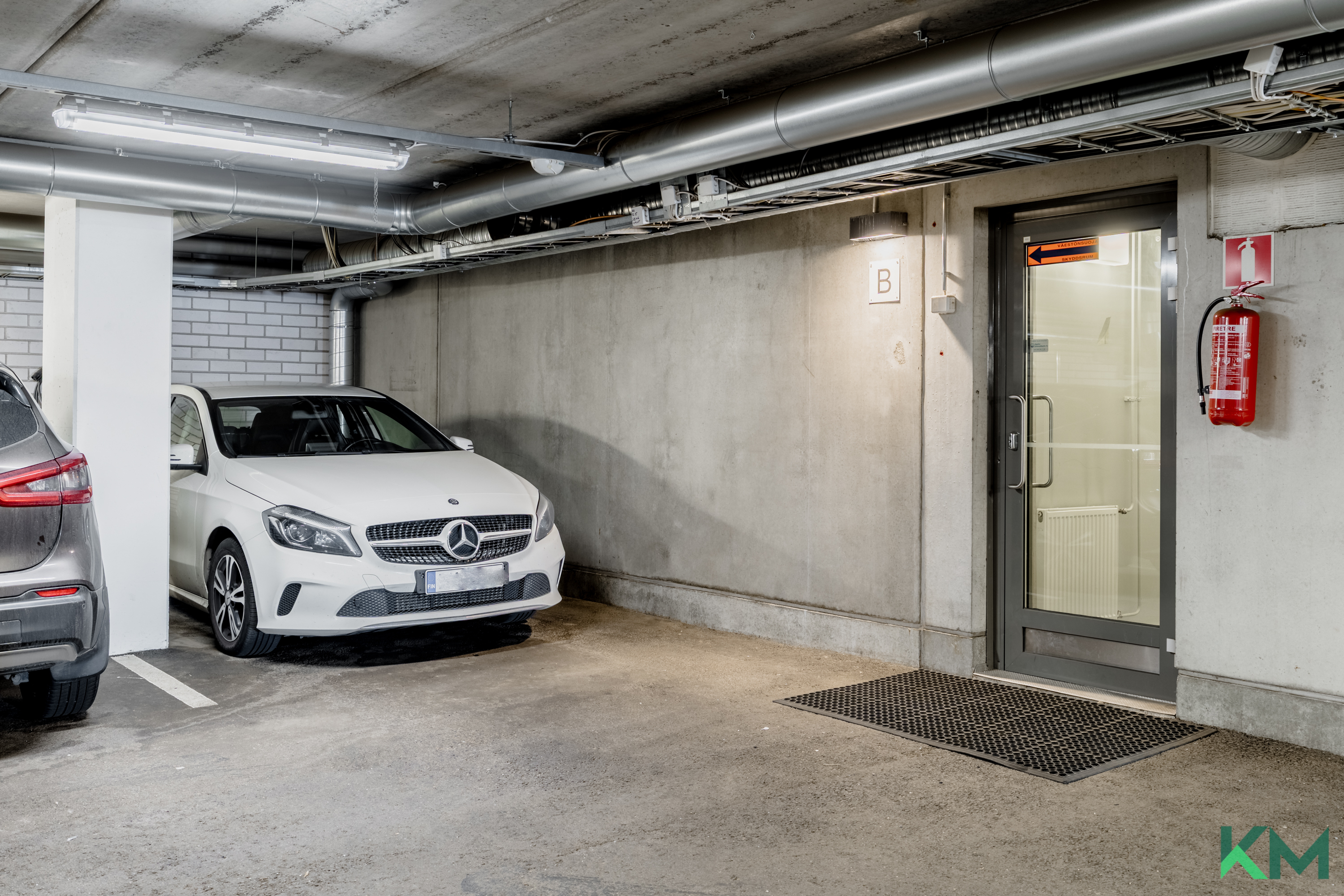 Autopaikka sisäänkäynnin vieressä