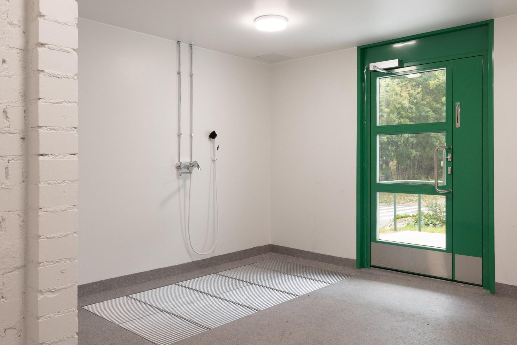 Sisäänkäynnin yhteydessä pesupiste polkupyörille ja lastenvaunuille