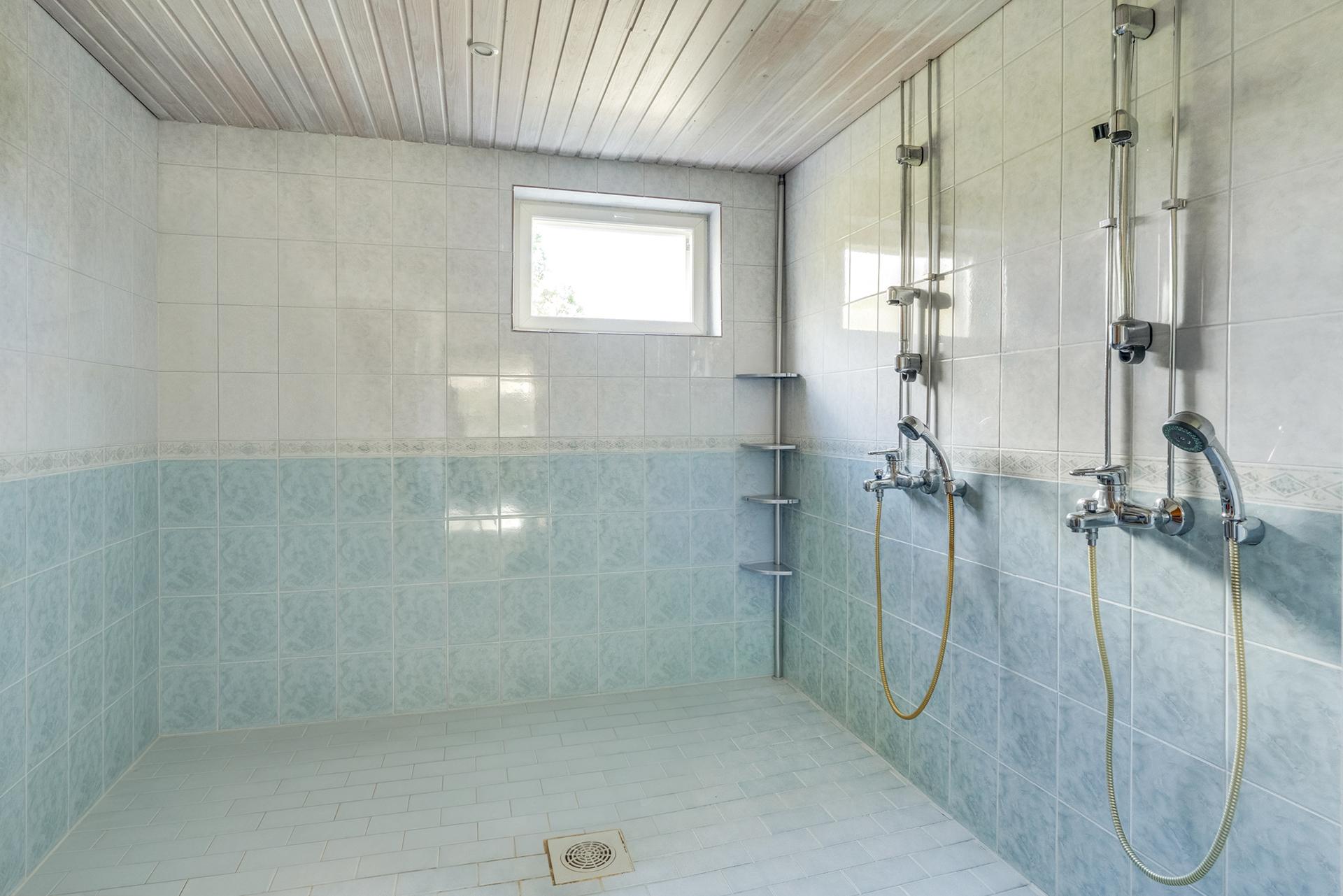 Iso kylpyhuone kahdella suihkulla