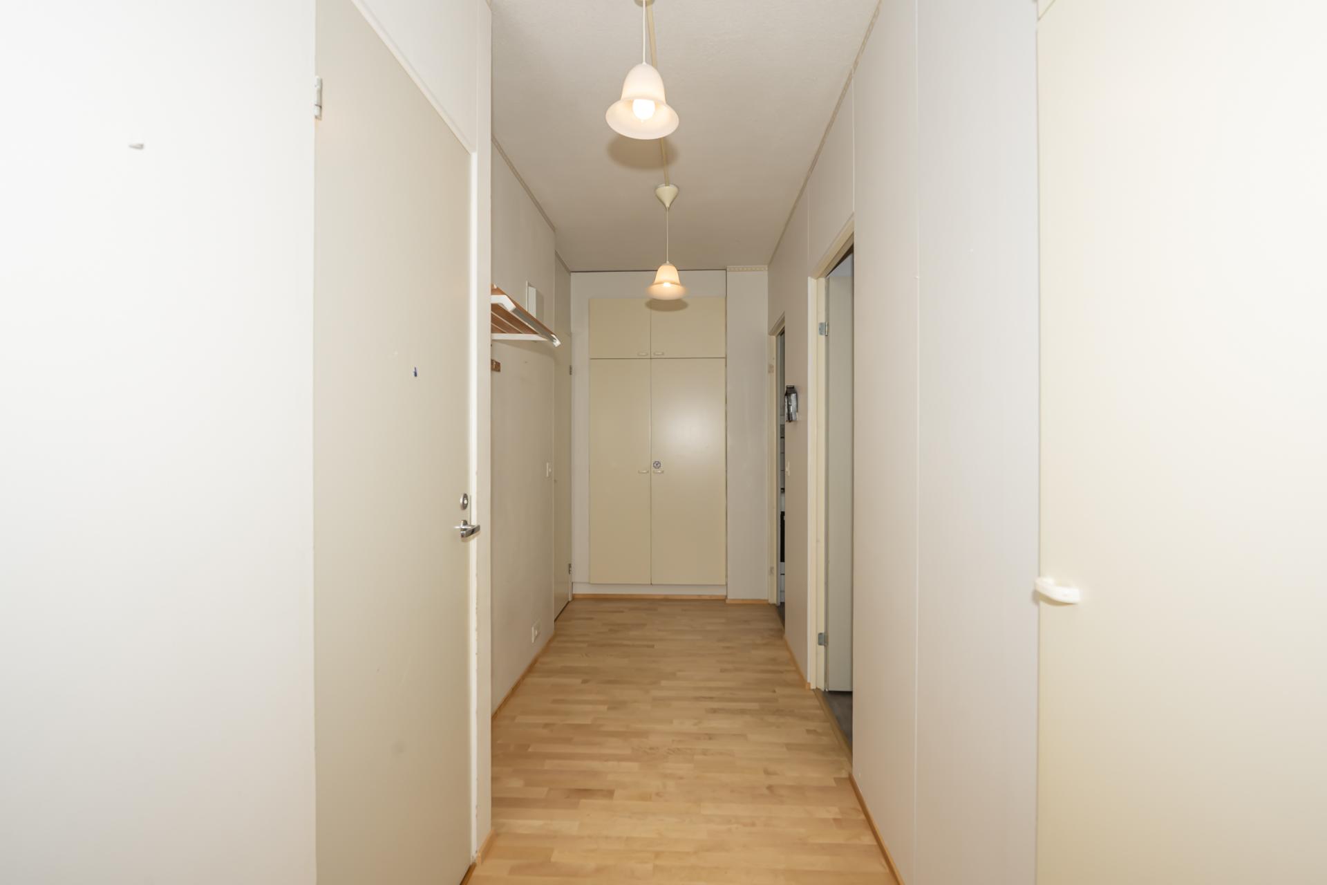 Olohuoneen suunnasta näkymä eteiseen. Oikealla ja sisääntulossa kaapistoja. 