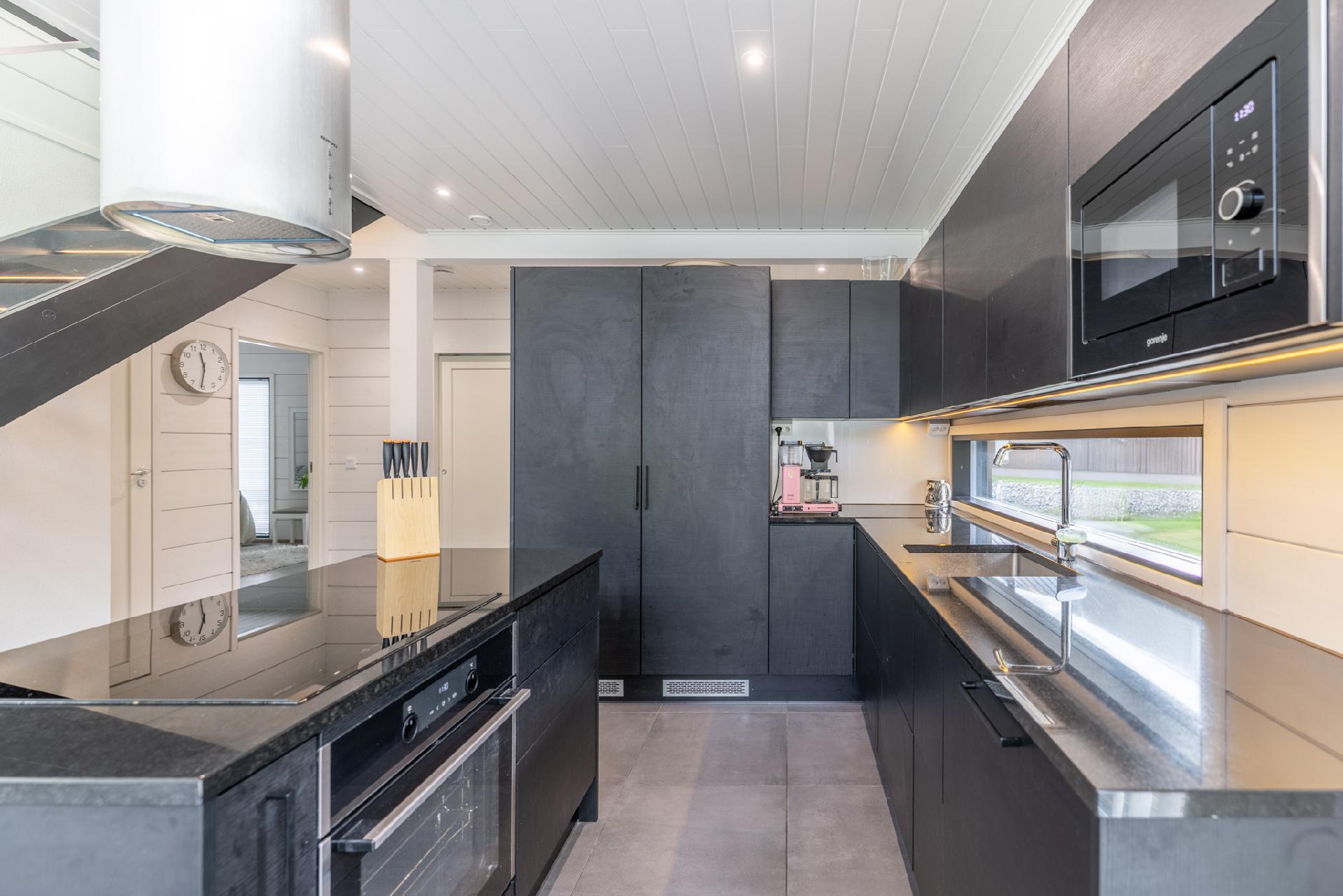 Minamalistinen ja toimiva keittiö, jossa kaikki on käden ulottuvilla.