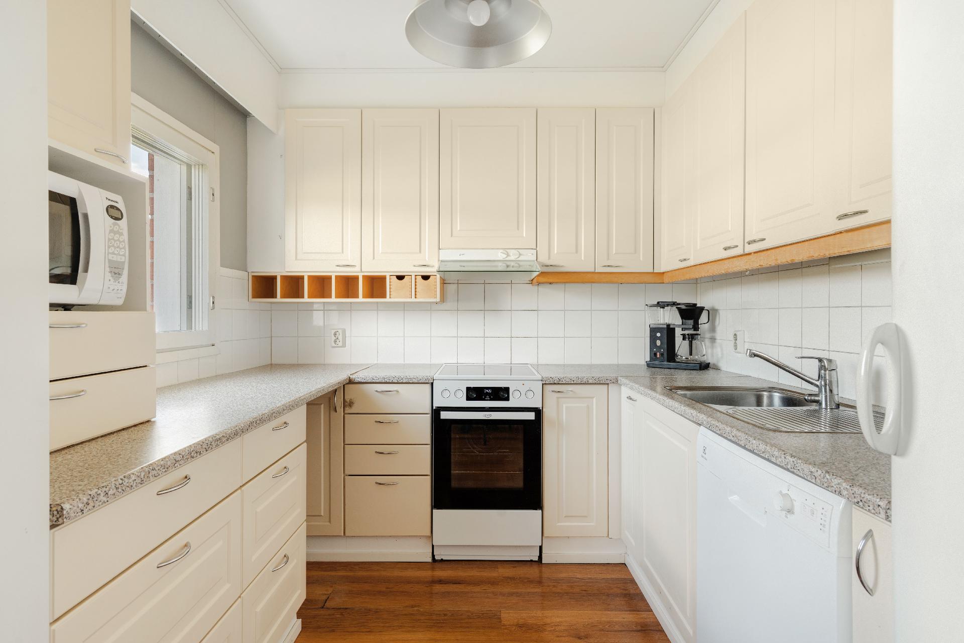 Tilava keittiö, vasemmalla ikkuna pellon suuntaan.