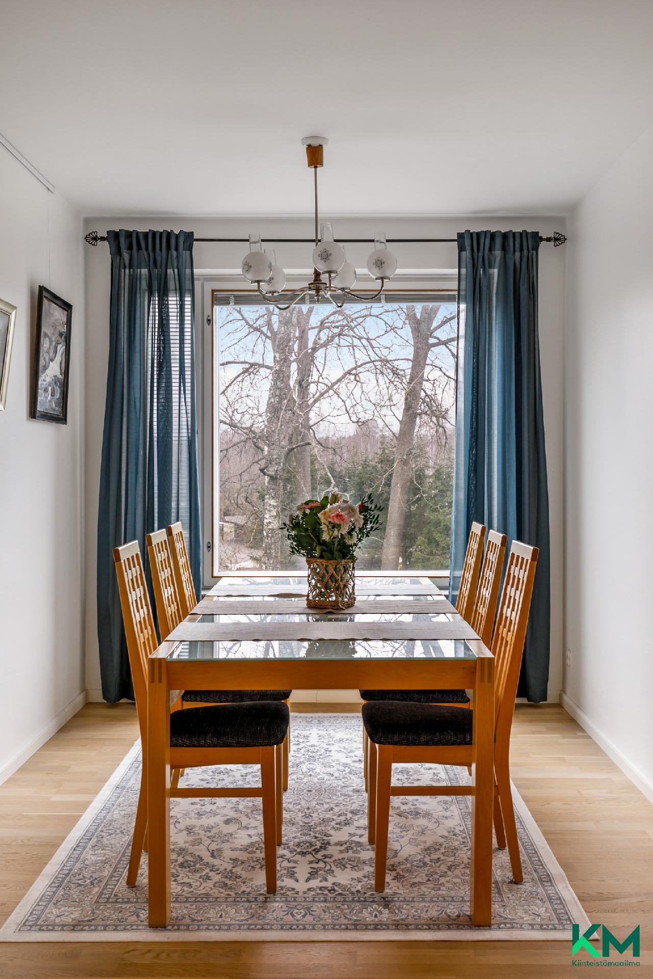 Valoisassa ruokailutilassa on iso ikkuna länteen - Det finns ett stort fönster mot väst i matsalen