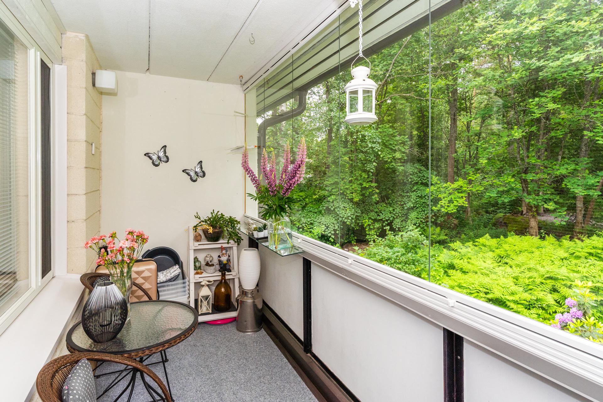 Lasitettu parveke, josta vehreät näkymät.