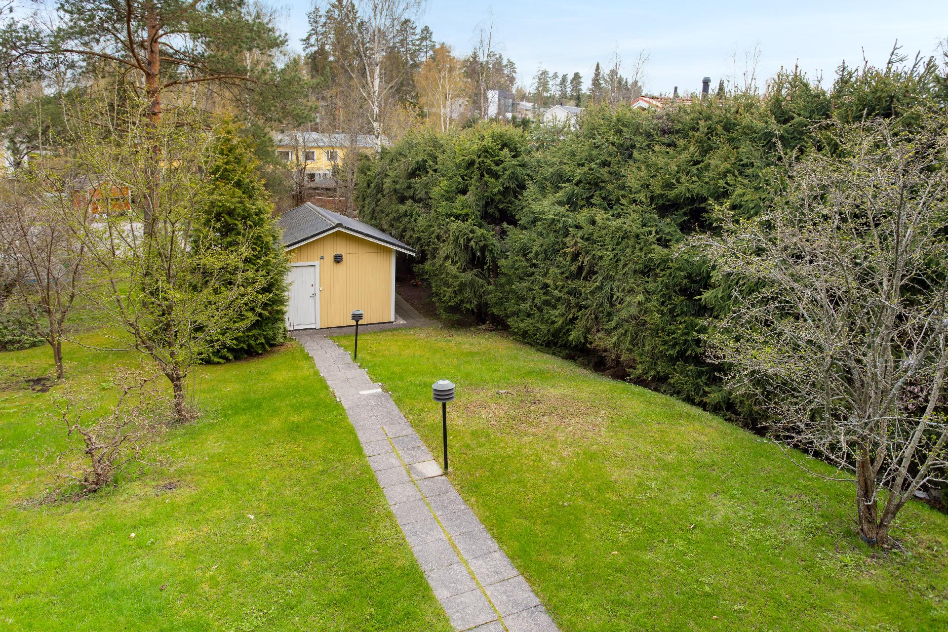 Tallin takana on Pisantie, josta on toinen käynti tontille ja yksi lähi bussipysäkeistä.