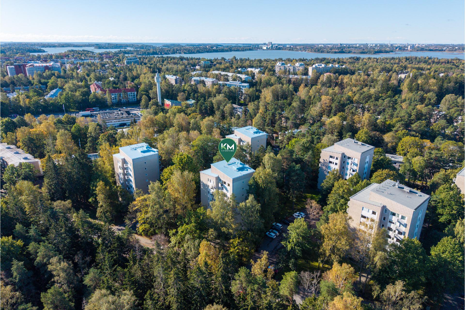 Munkkivuoren vehreä ympäristö. Ostoskeskus taustalla.