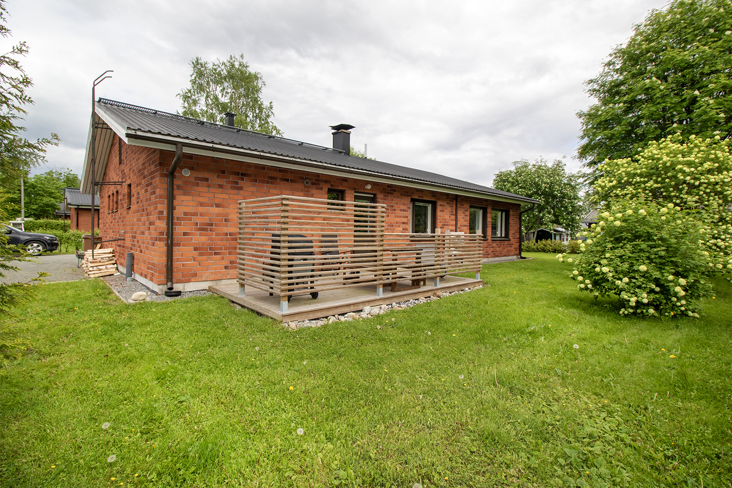 Vehreällä takapihalla terassi.