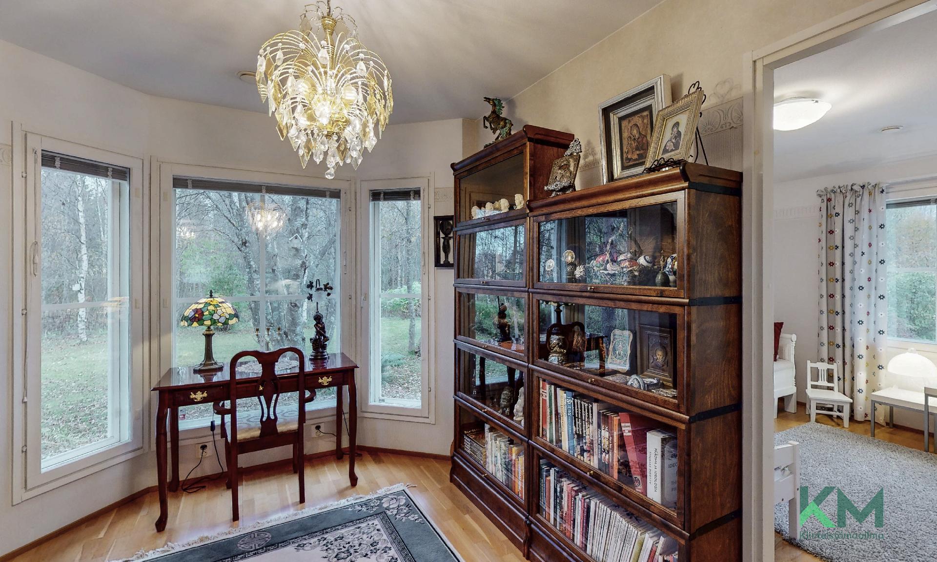 Kirjastohuoneen ikkunat maksimoivat luonnonvalon tähän huoneeseen. Oikealla näkyy myös vilaus kolmannesta makuuhuoneesta.