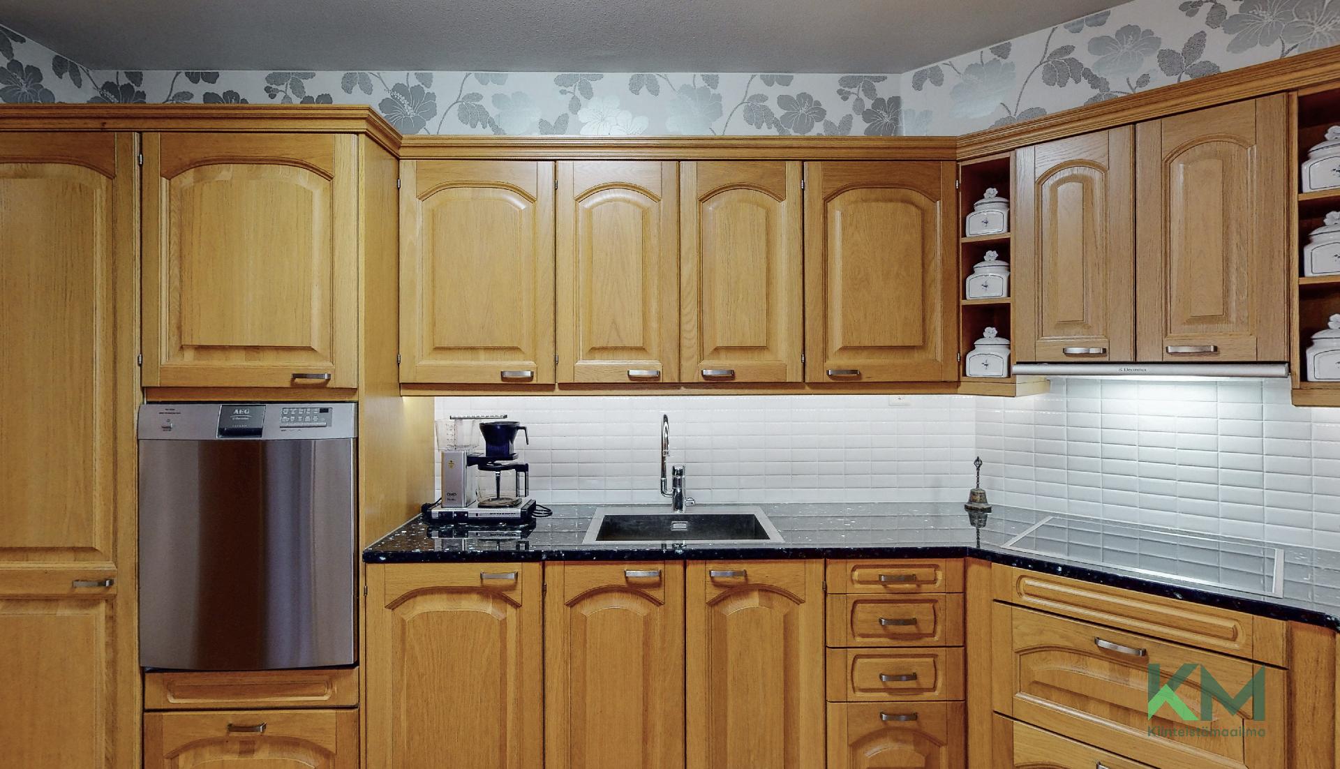 Laadukkaassa Puustellin keittiössä on kauniit puuovet. Tästä keittiöstä ei tila lopu kesken.