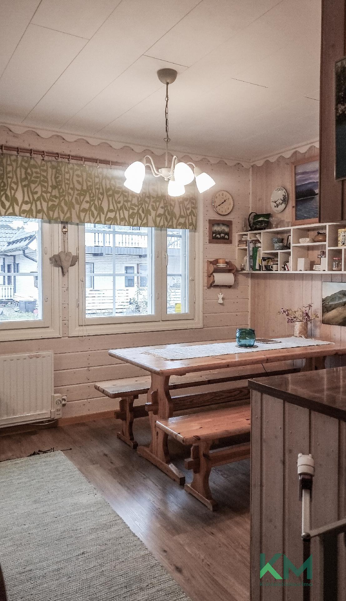 Kuuden hengen ruokapöytä on sijoitettu keittiöön.