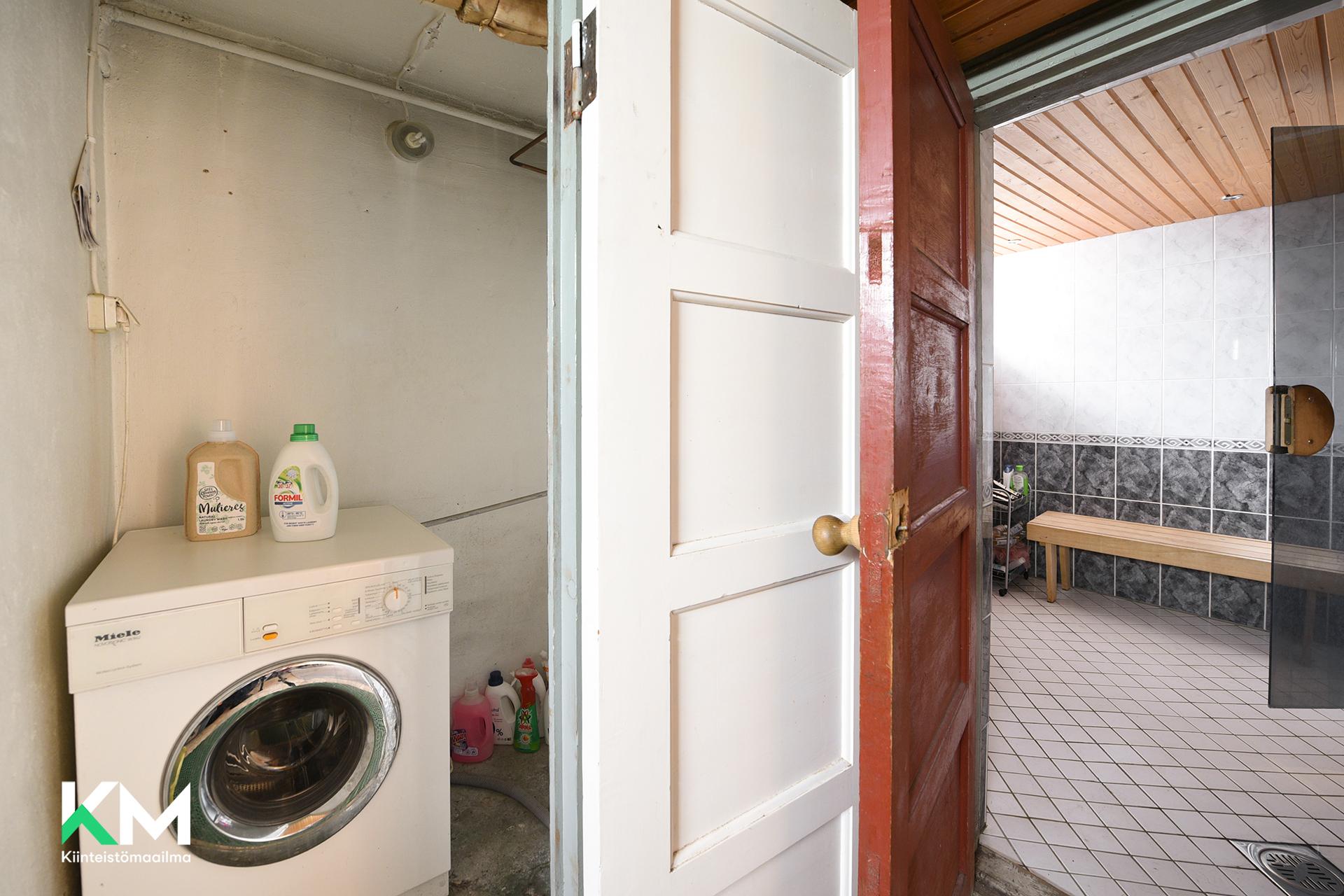 Pyykinpesukone ja ovi kylpyhuoneeseen