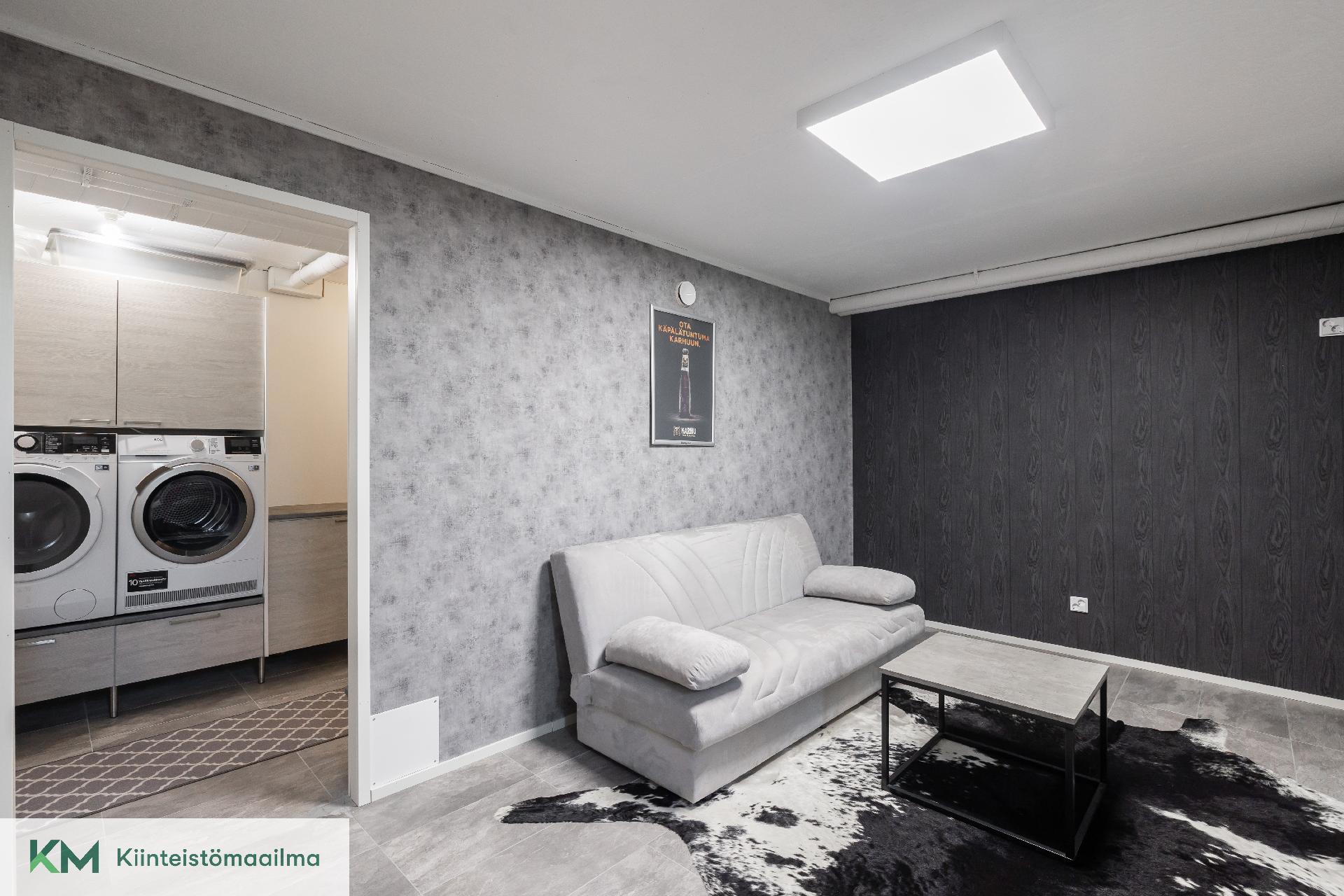 Alakerran oleskelutila ja kodinhoitohuone.