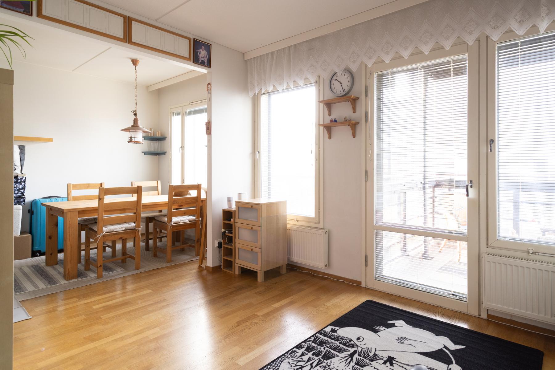 Ruokailutila ja olohuonetta sekä käynti parvekkeelle