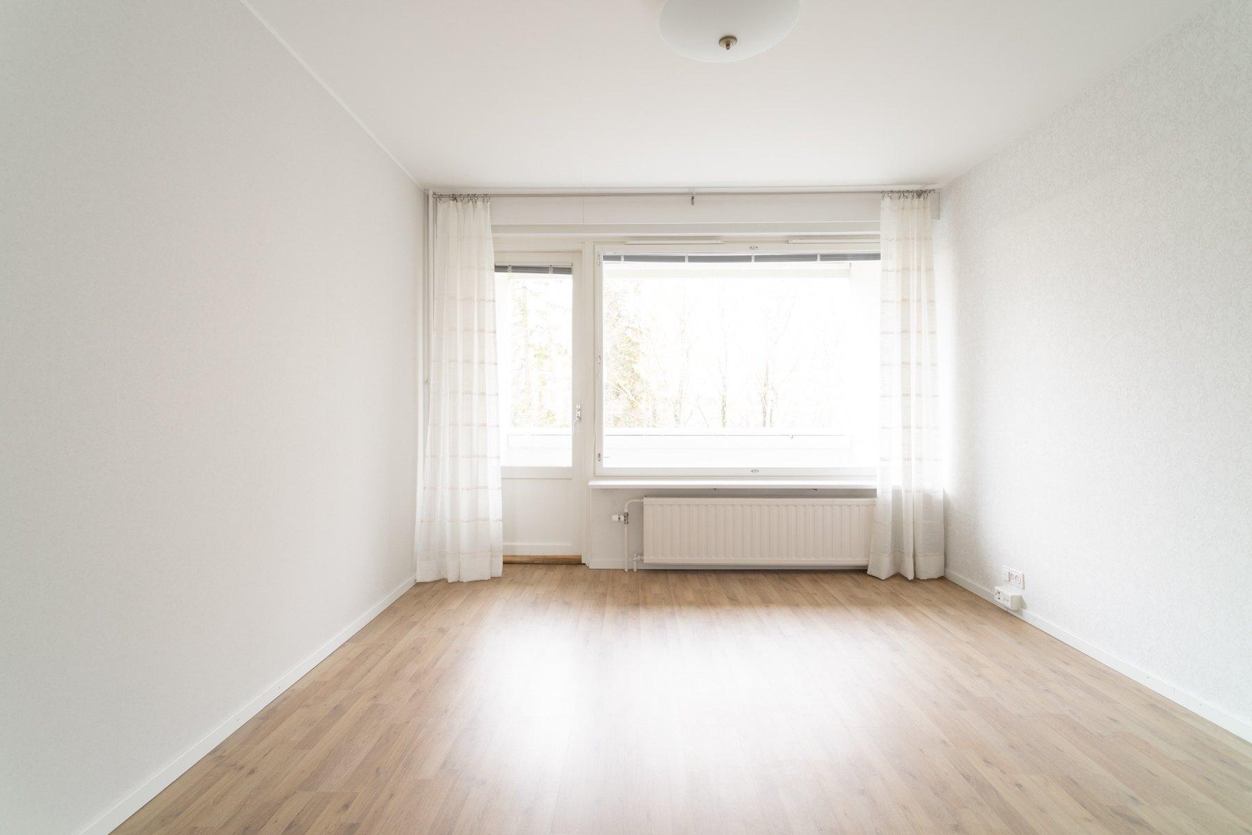 Valoisa olohuone, käynti lasitetulle parvekkeelle