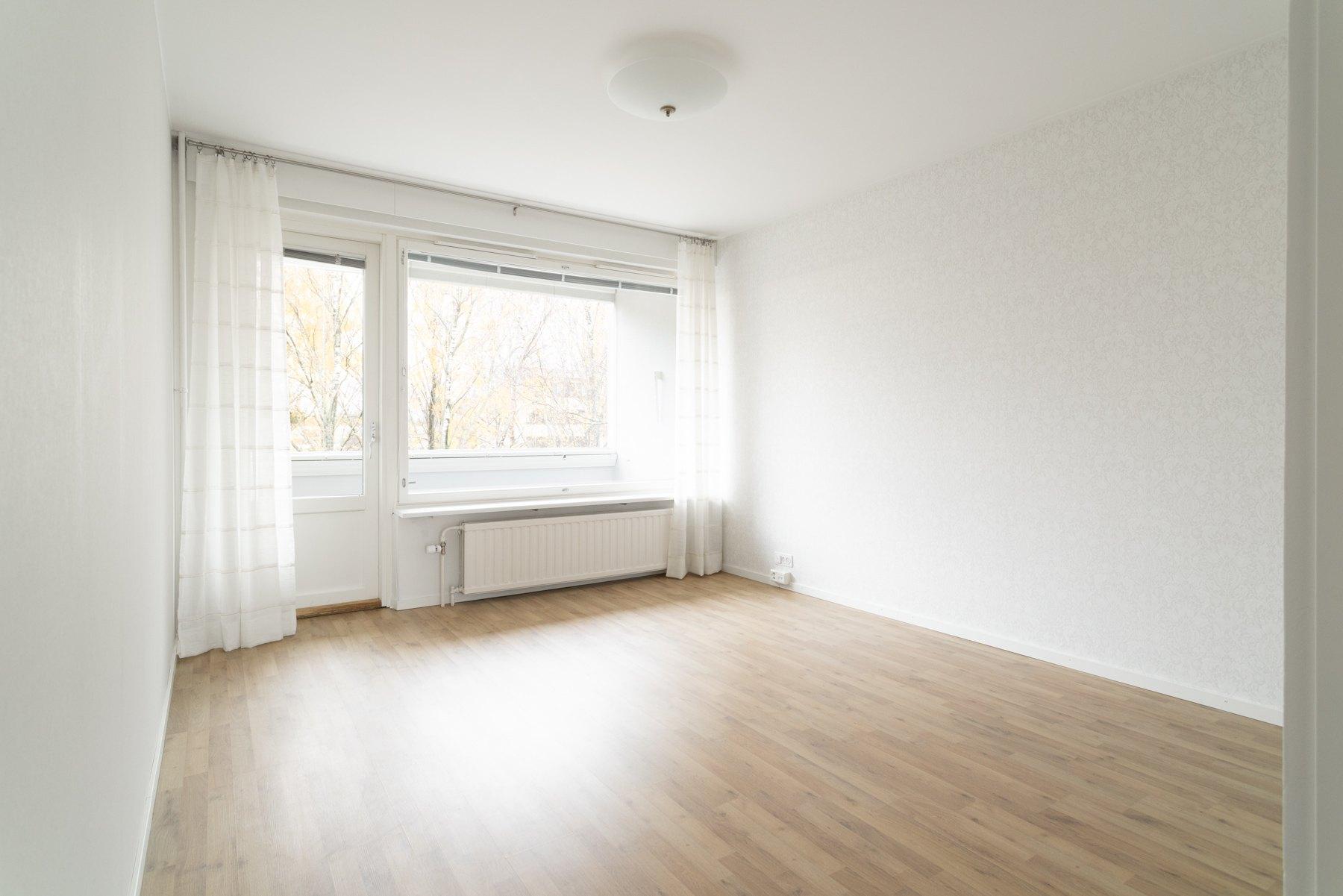 Valoisa olohuone, käynti lasitetulle parvekkeelle