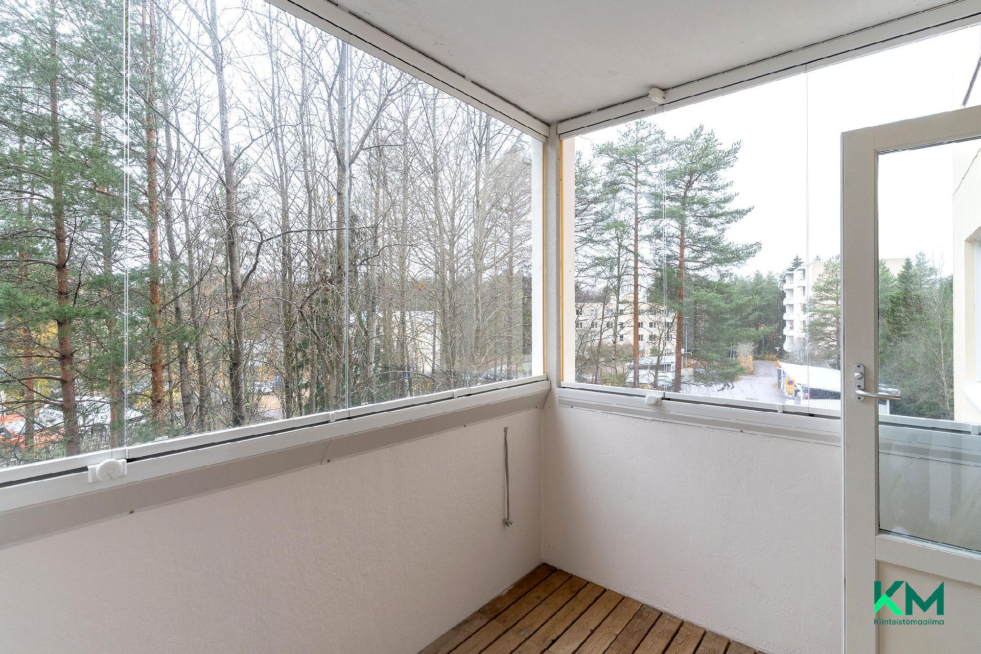 Lasitetulta parvekkeeta näkymä puustoiselle piha-alueelle.