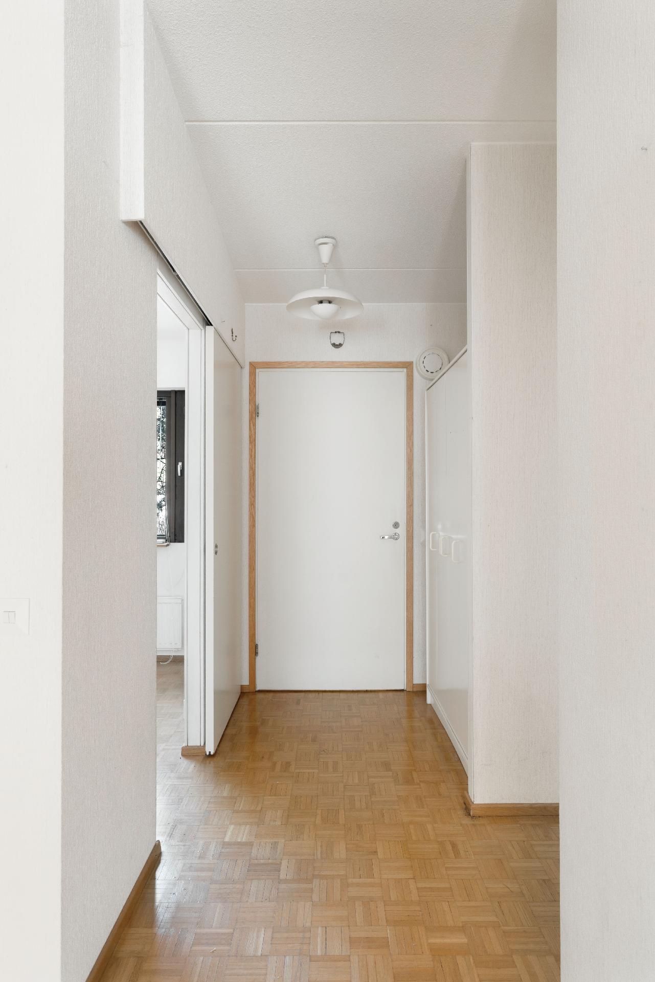 Keittiö vasemmalla ja toinen makuuhuoneista oikealla.