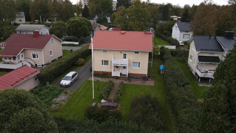 Vehreä piha ja kivitalo