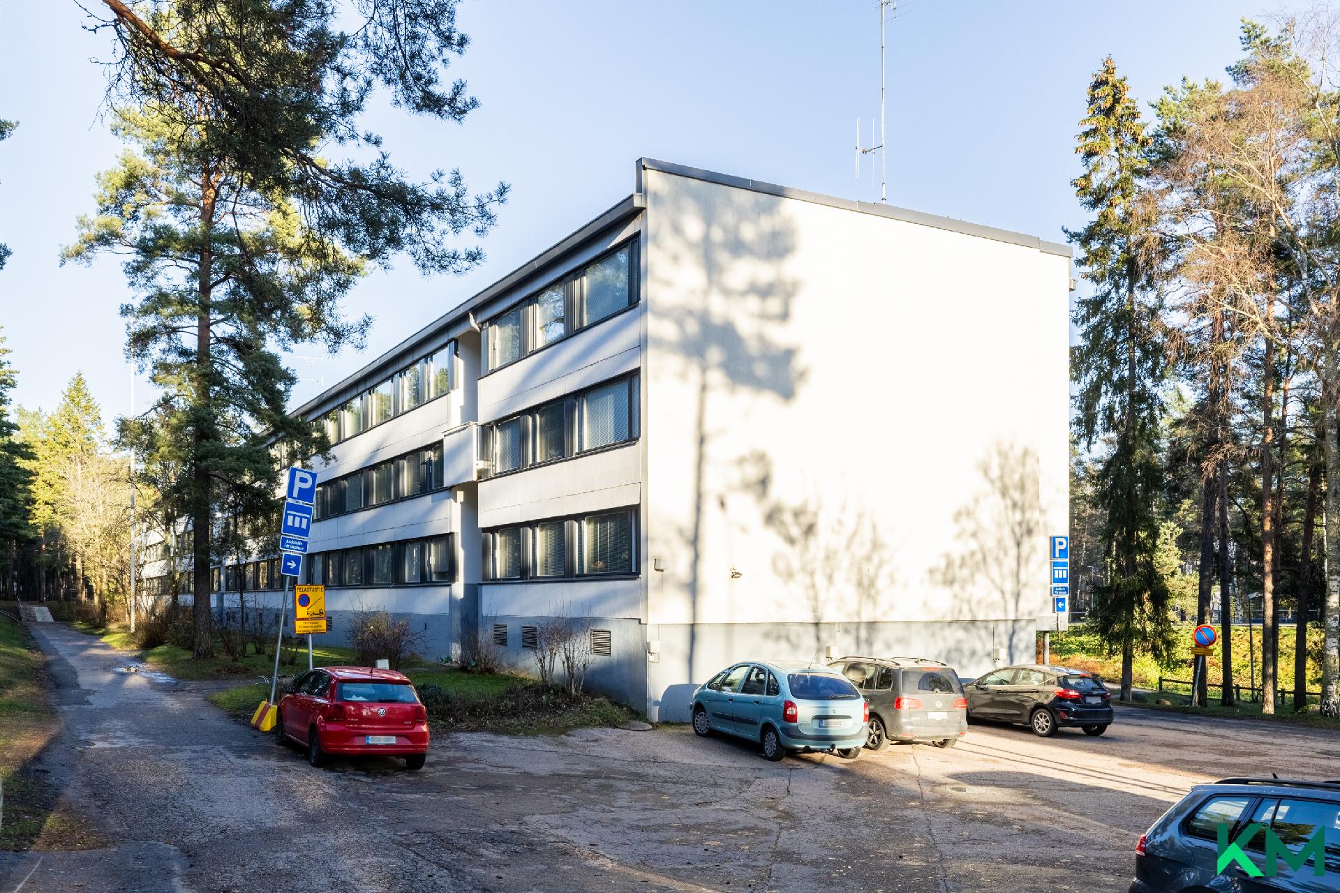 Pysäköintipaikkoja rakennuksen päädyssä