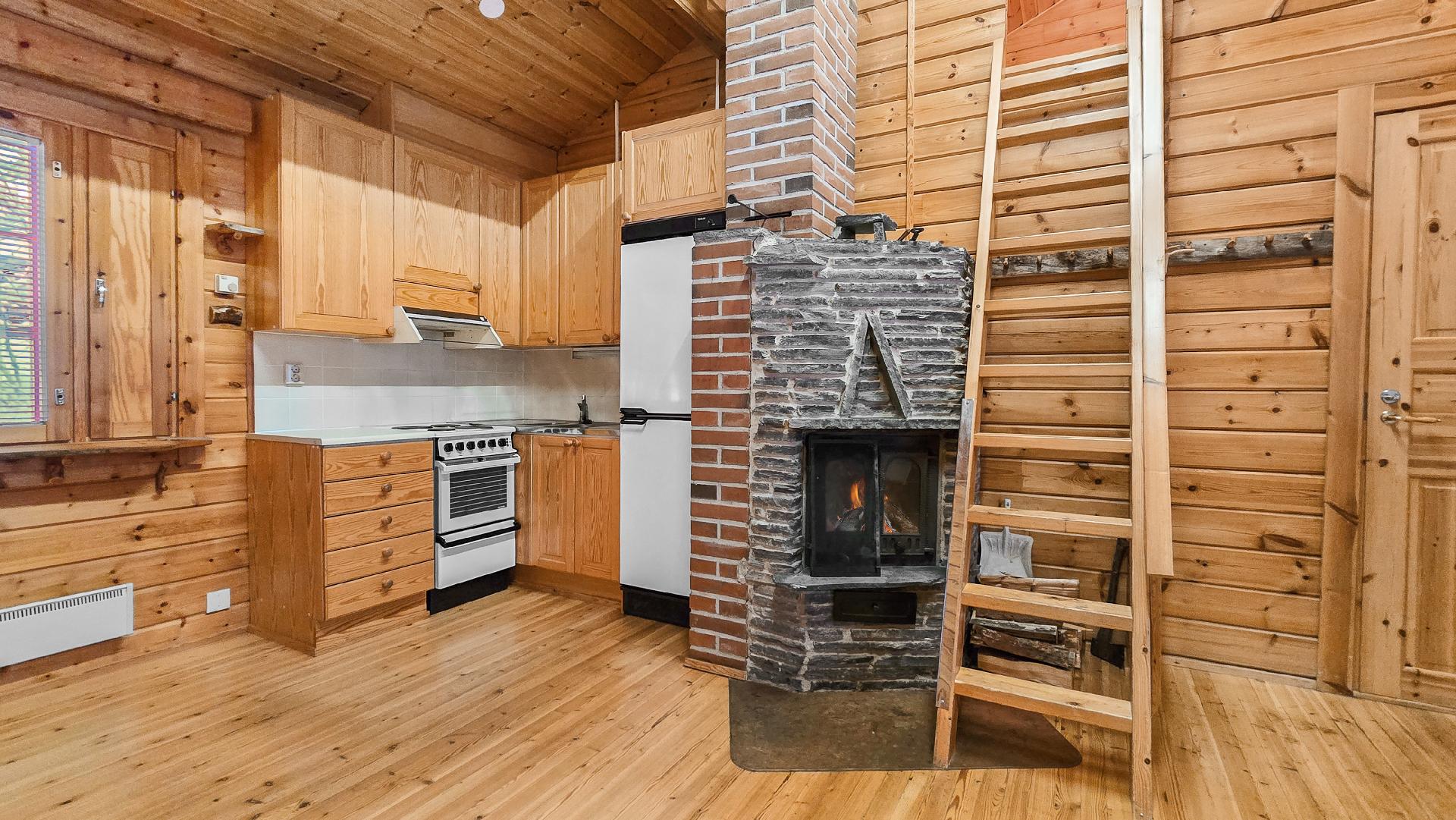 Keittiön vieressä varaava luonnonkivitakka sekä portaat parvelle