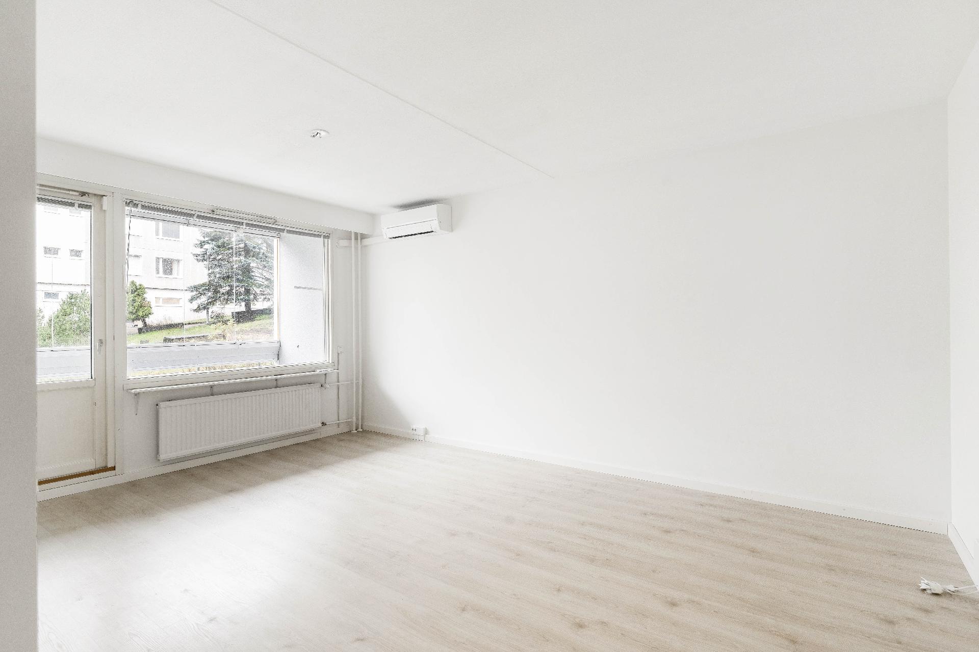 Valoisa olohuone, josta löytyy ilmalämpöpumppu kesähelteitä viilentämään.