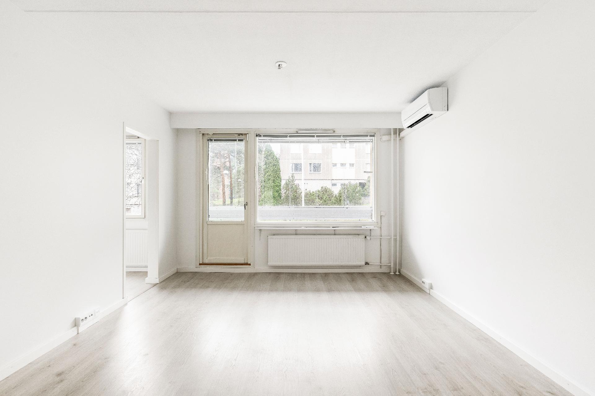 Olohuone jatkuu lasitetulle parvekkeelle ja perällä vasemmalla keittiö.