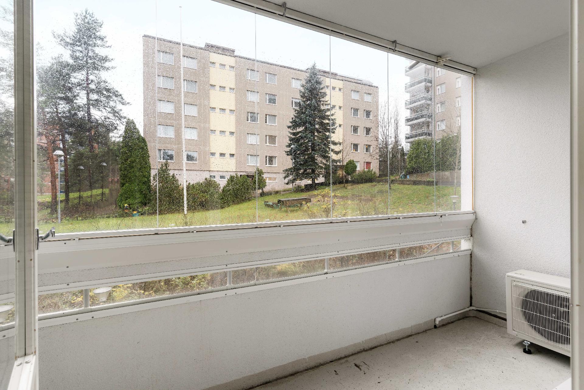 Lasitettu parveke vehreän sisäpihan suuntaan.