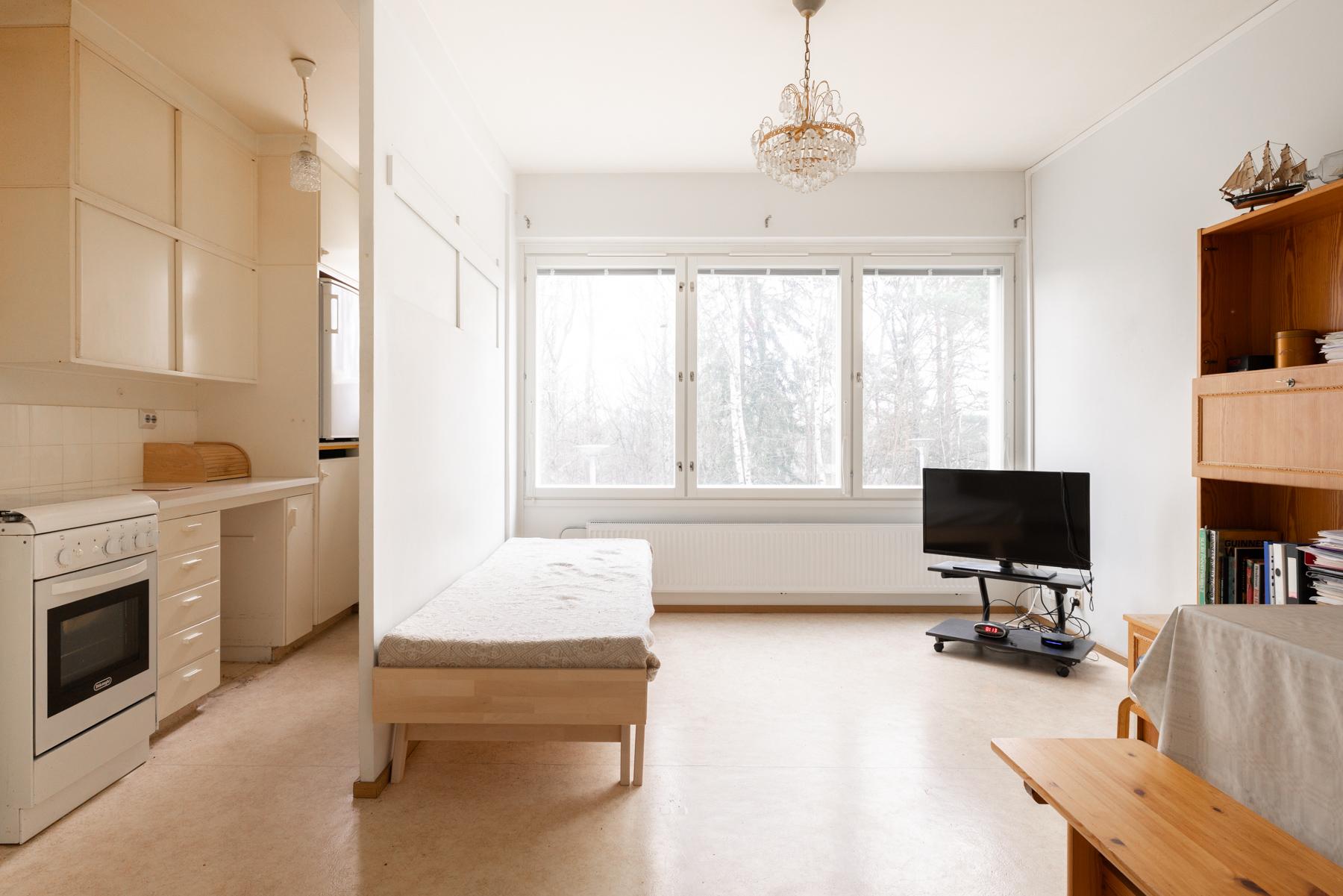 Olohuone, jonka yhteydessä kevyellä seinällä keittiö