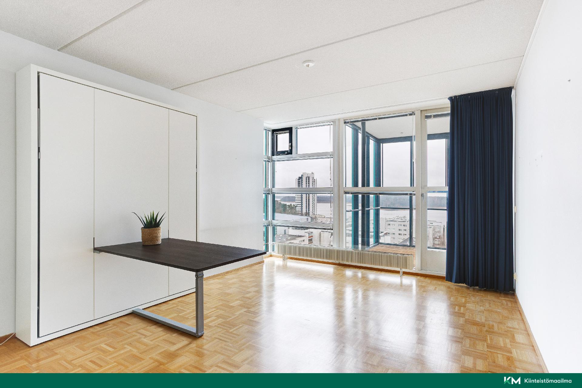 Tilava huone, seinäsänky, jossa pöytä