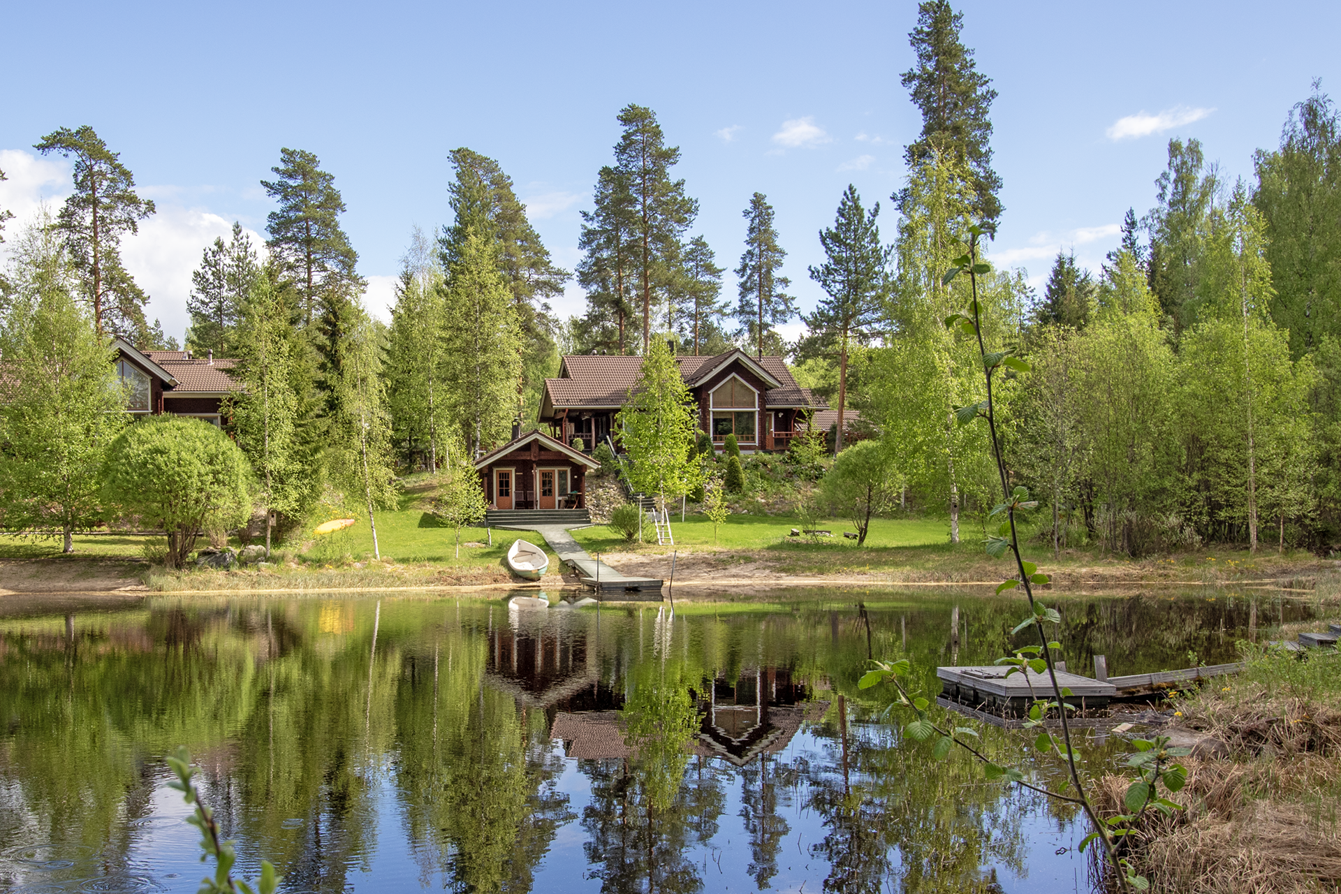 kesäinen kuva päämökistä ja rantasaunasta