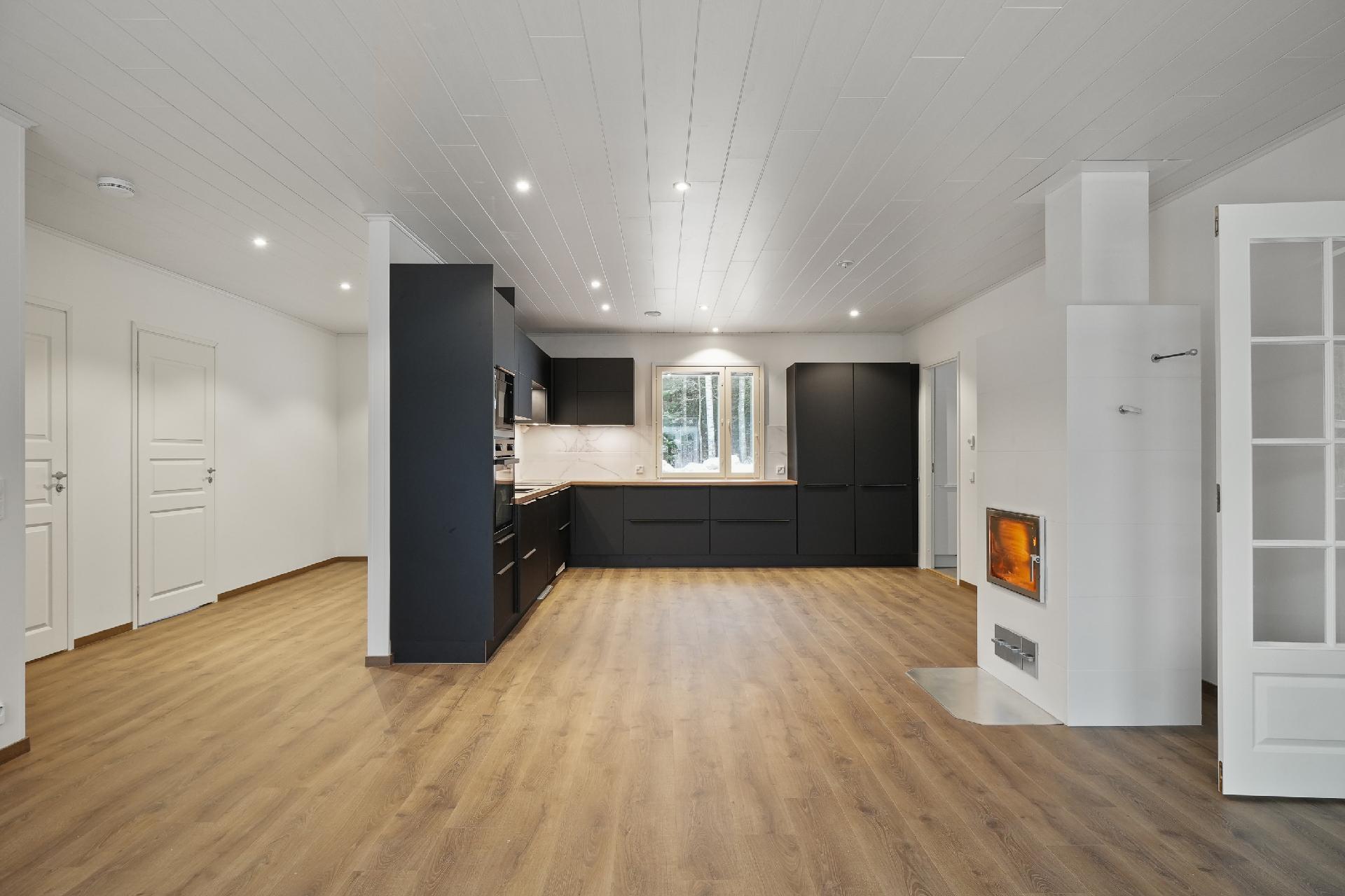 Vaaleaan kotiin tumma keittiö integroituine kodinkoneineen tuo kivasti vastakohtaa.