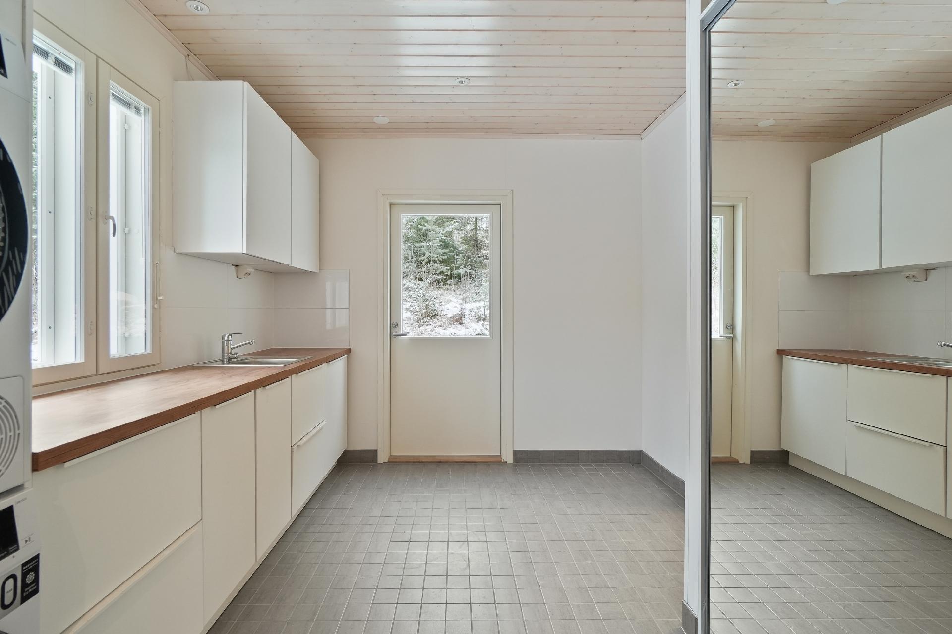 Kodinhoitohuone on tilava tasoineen ja kaapistoineen.