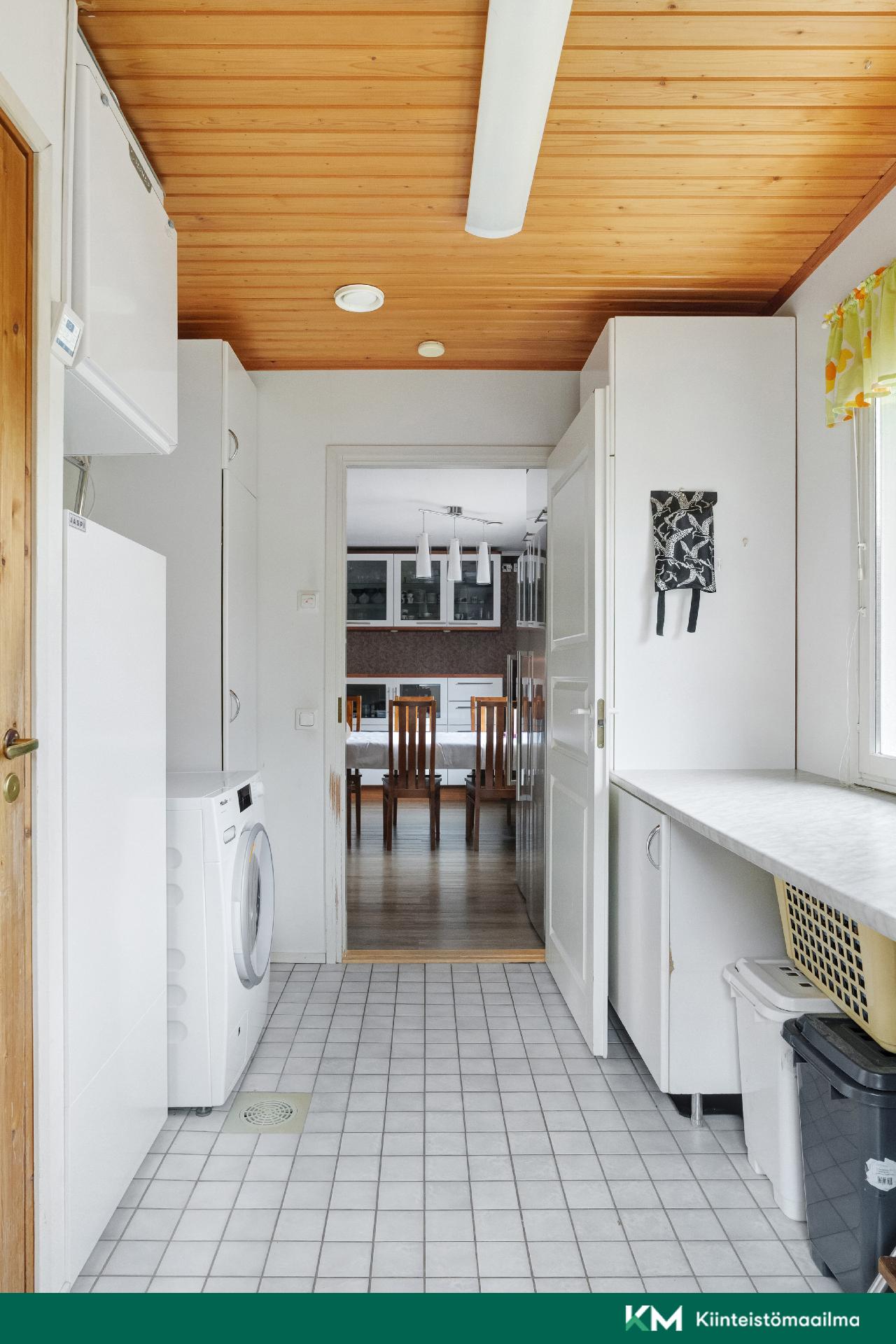 Kodinhoitohuoneesta näkymä keittiöön.