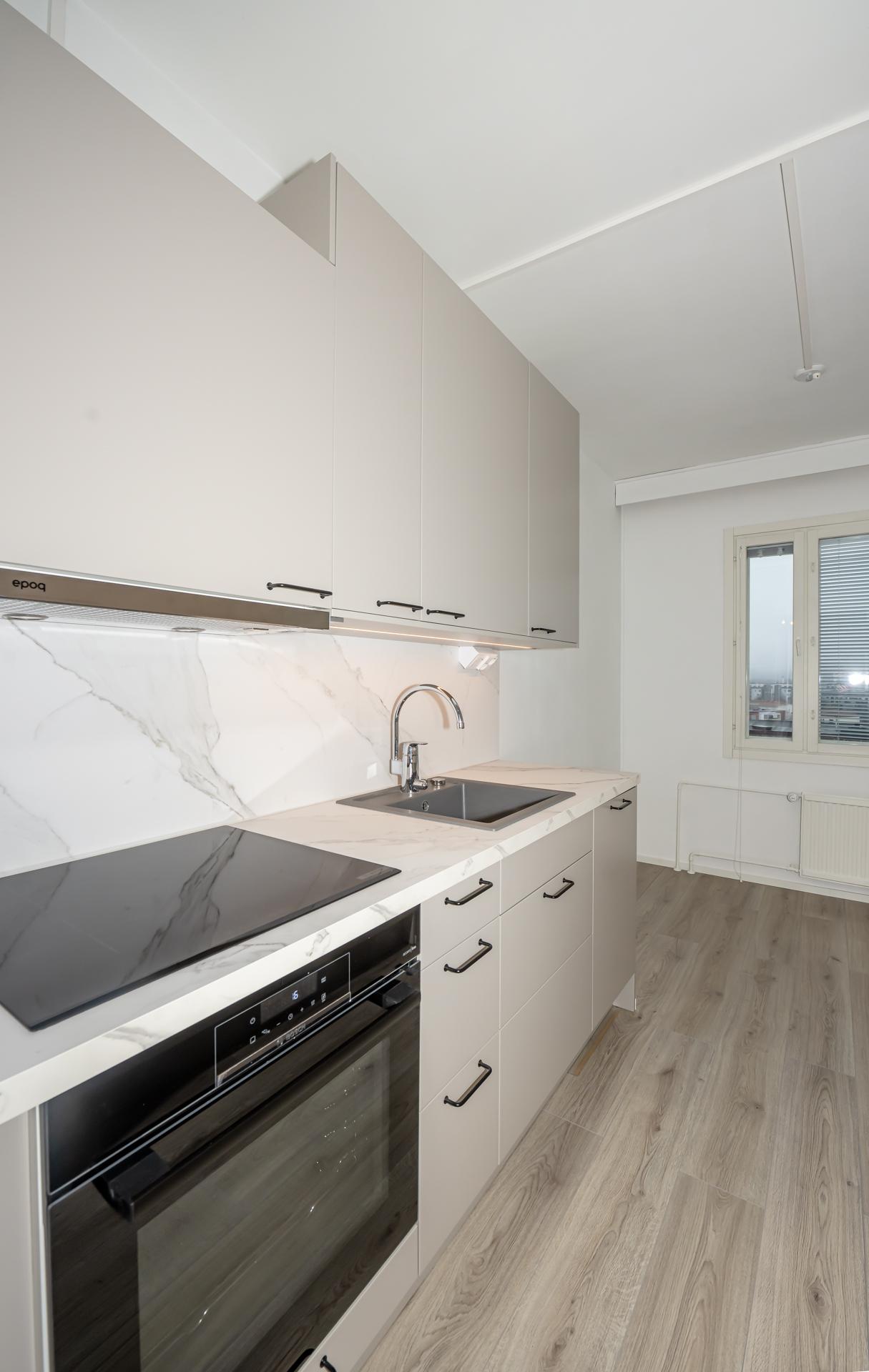 Keittiön ilmettä uusittuine kalusteineen ja kodinkoneineen.