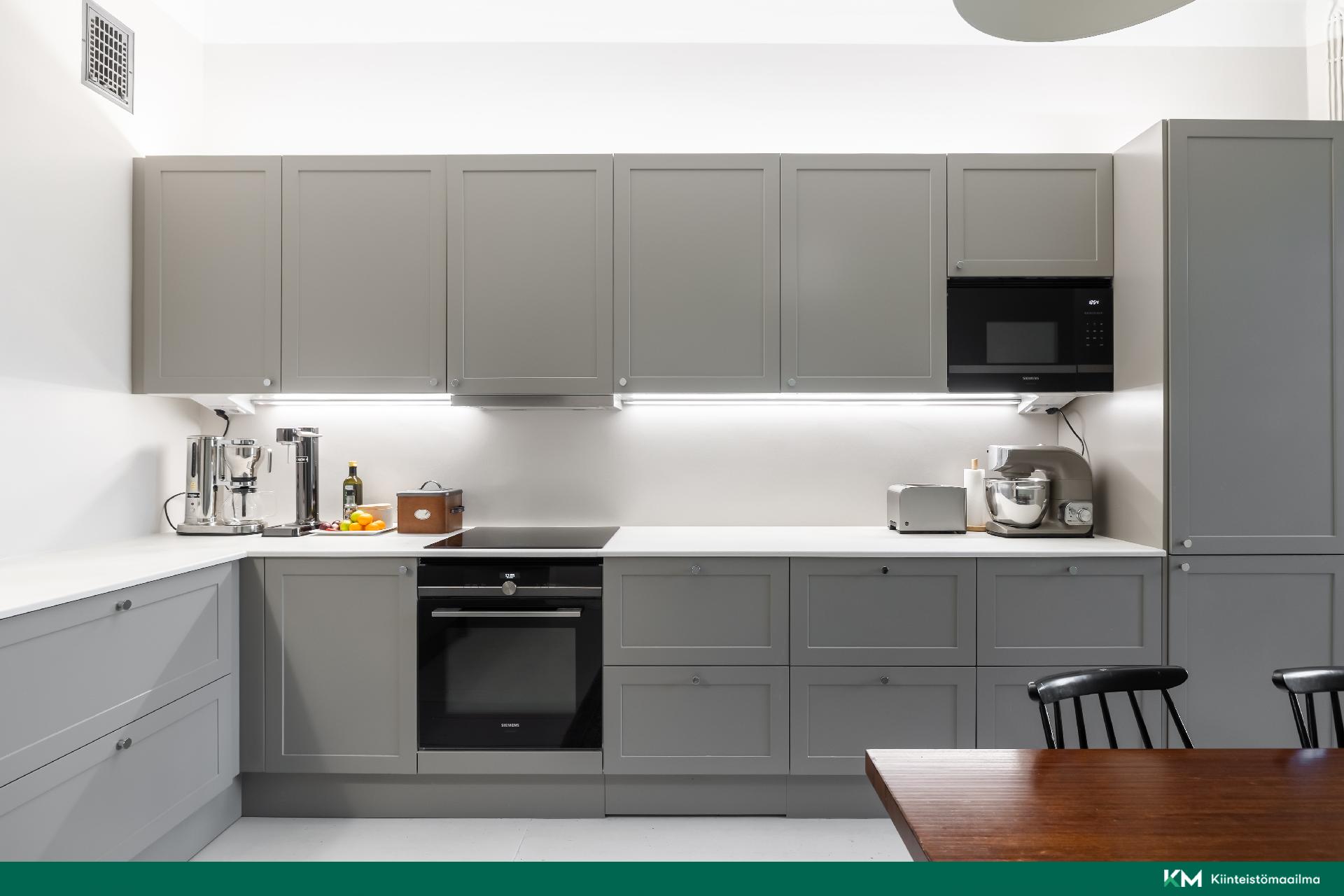 Keittiön yleisilme on seesteinen ja tyylikäs integroitujen kodinkoneiden ansiosta