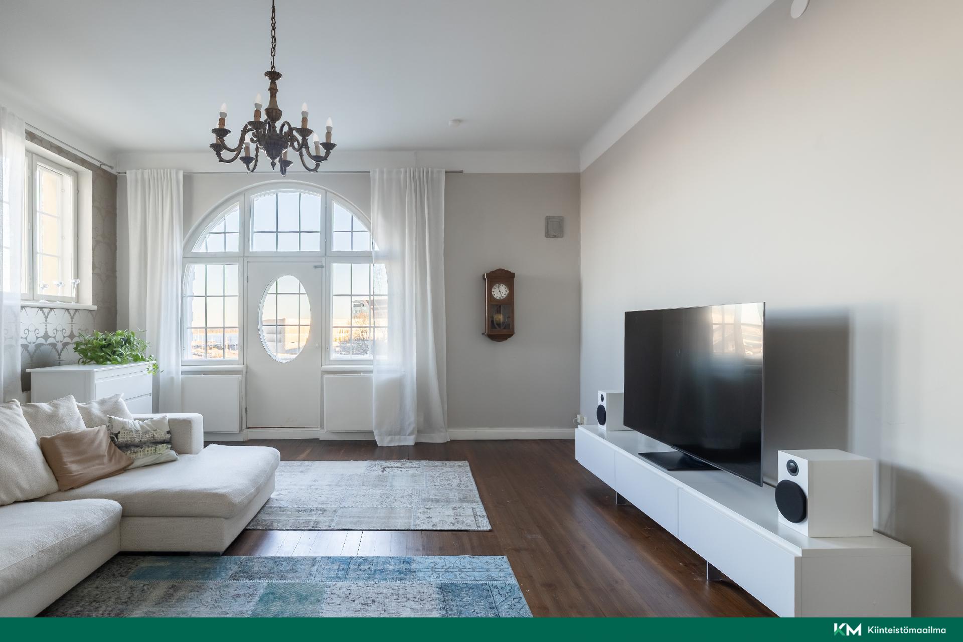 Olohuoneen katseenvangitsija on kaunis puolikaaren muotoinen ikkuna ja kulku parvekkeelle