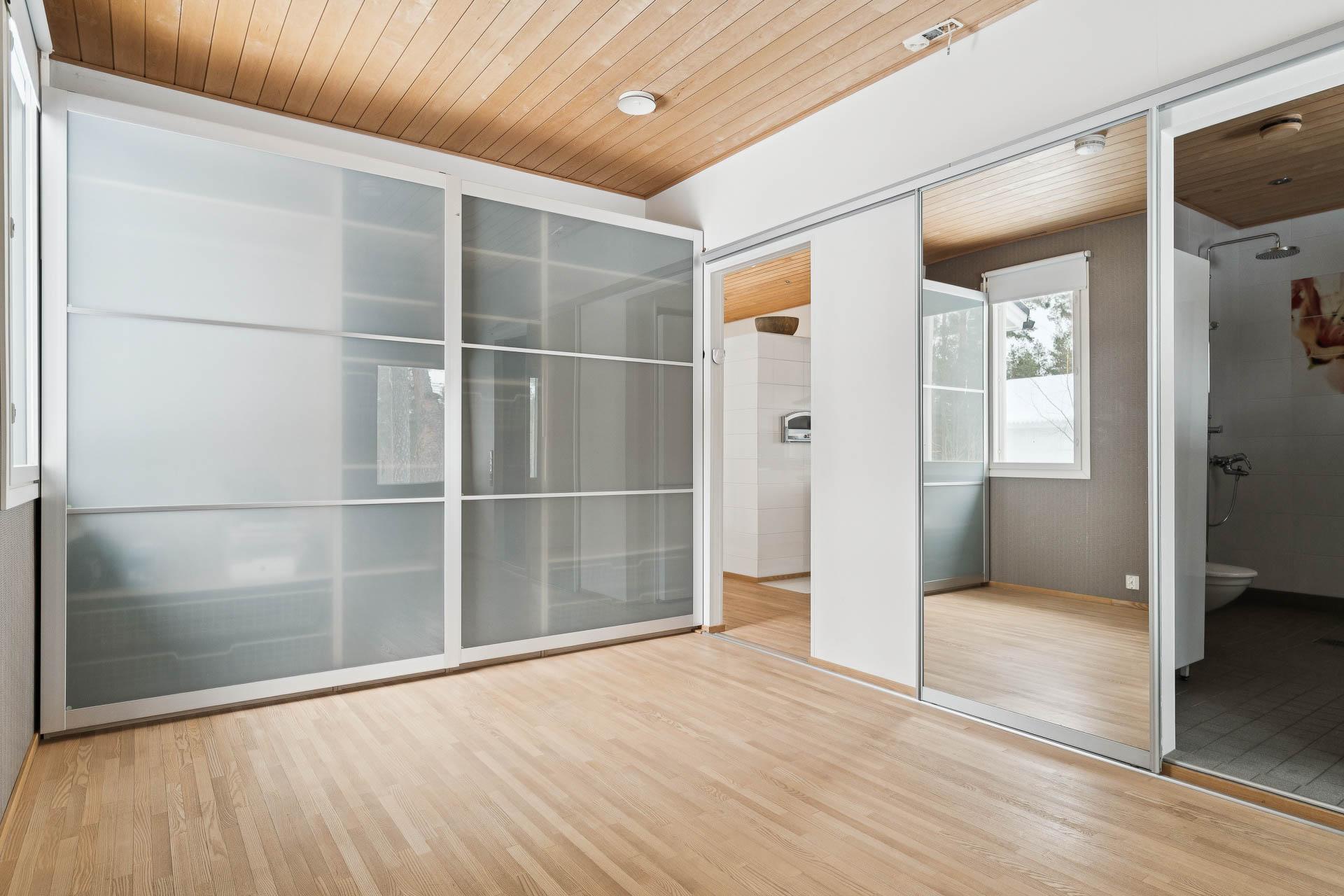 Suurempi makuuhuone, josta käynti kylpyhuoneeseen ja terassille