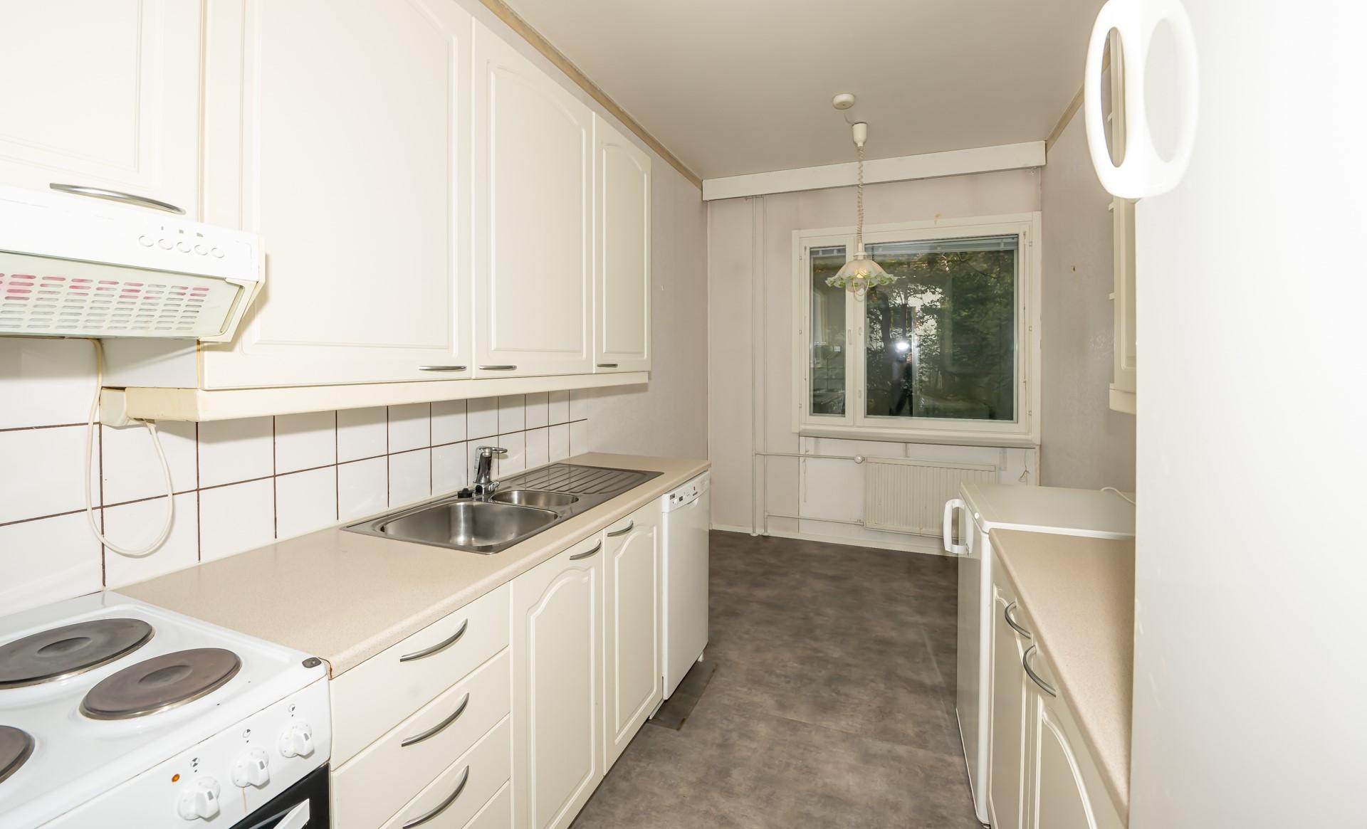 Kodikkaassa keittiössä on kaapistoja ja tasoja molemmin puolin.