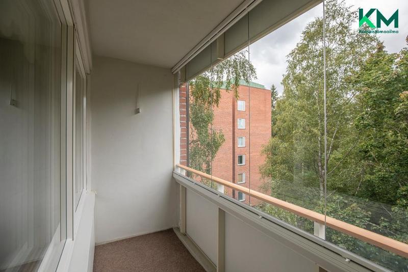 Lasitettu parveke avautuu vehreän pihan ja puiston puolelle.