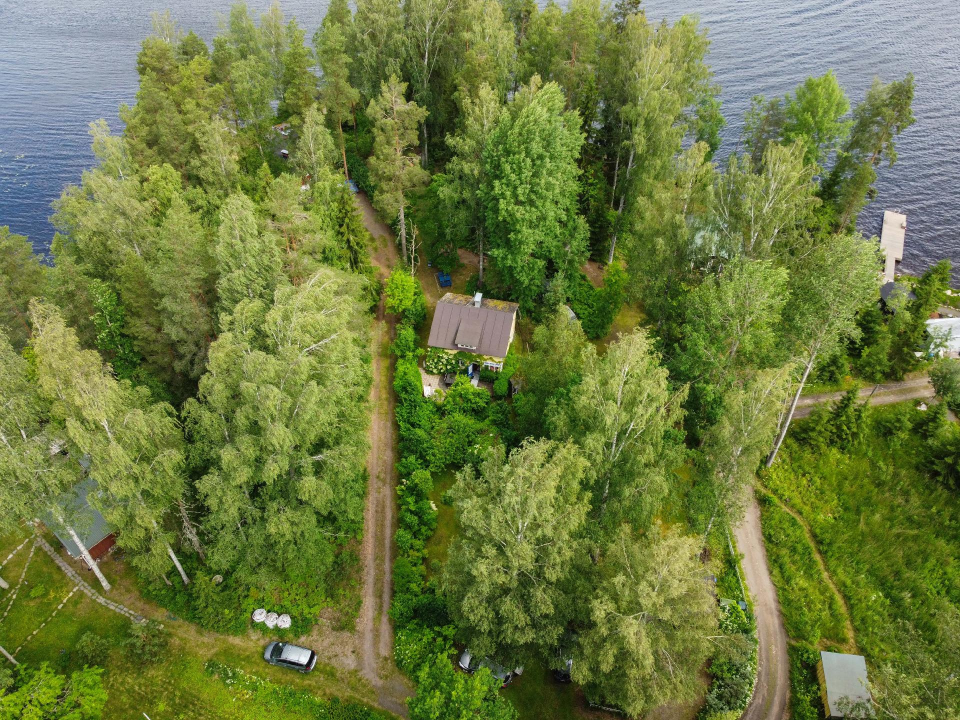Monimuotoinen tontti: puutarhaa, metsämaastoa ja ranta-alue.