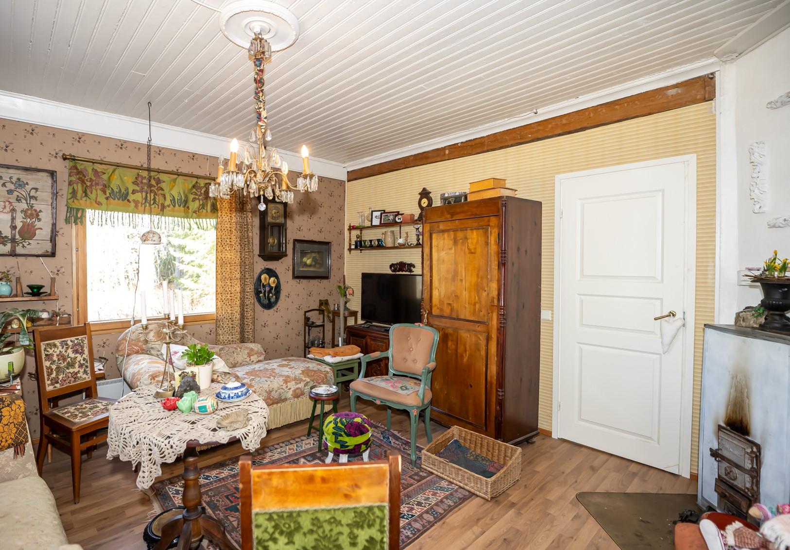 Tunnelmallinen olohuone, ovi johtaa makuuhuoneeseen.