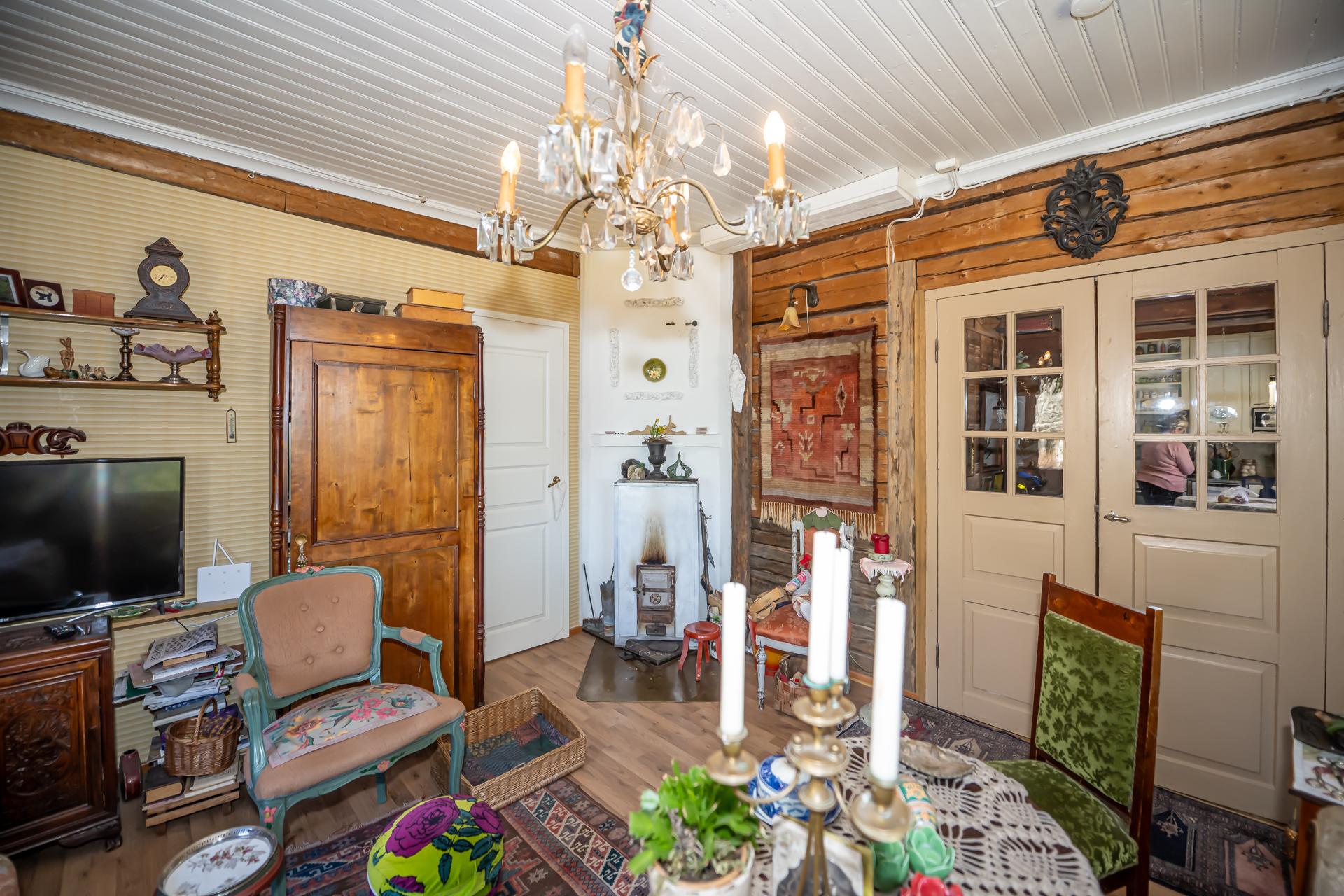 Olohuoneessa on kauniit pariovet ja hirsiseinää. Lämmönlähteenä on Porin Matti.