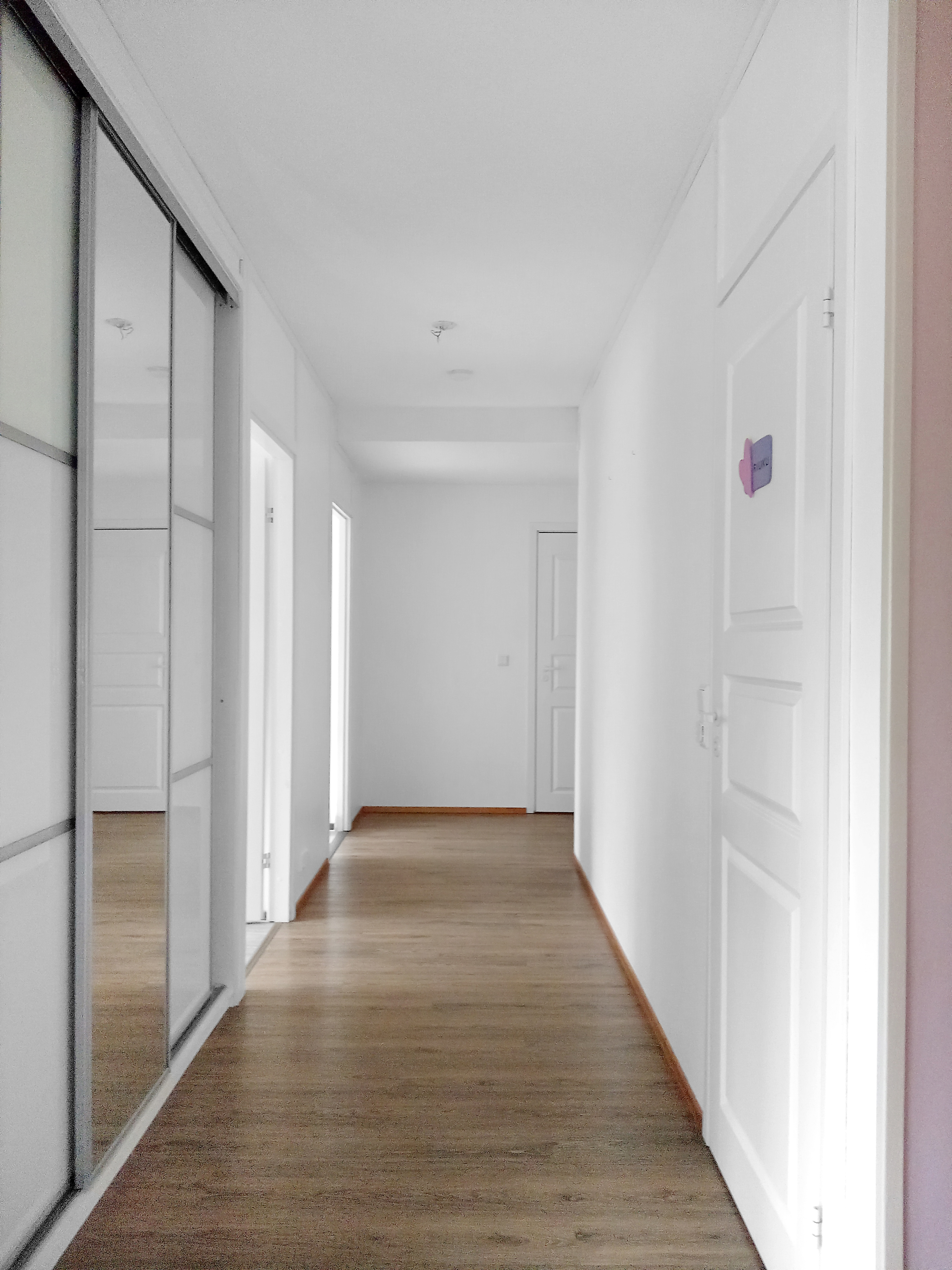 Eteiskäytävä. Vasemmalla liukuovikaapisto, oikealla ovi kylpyhuoneeseen