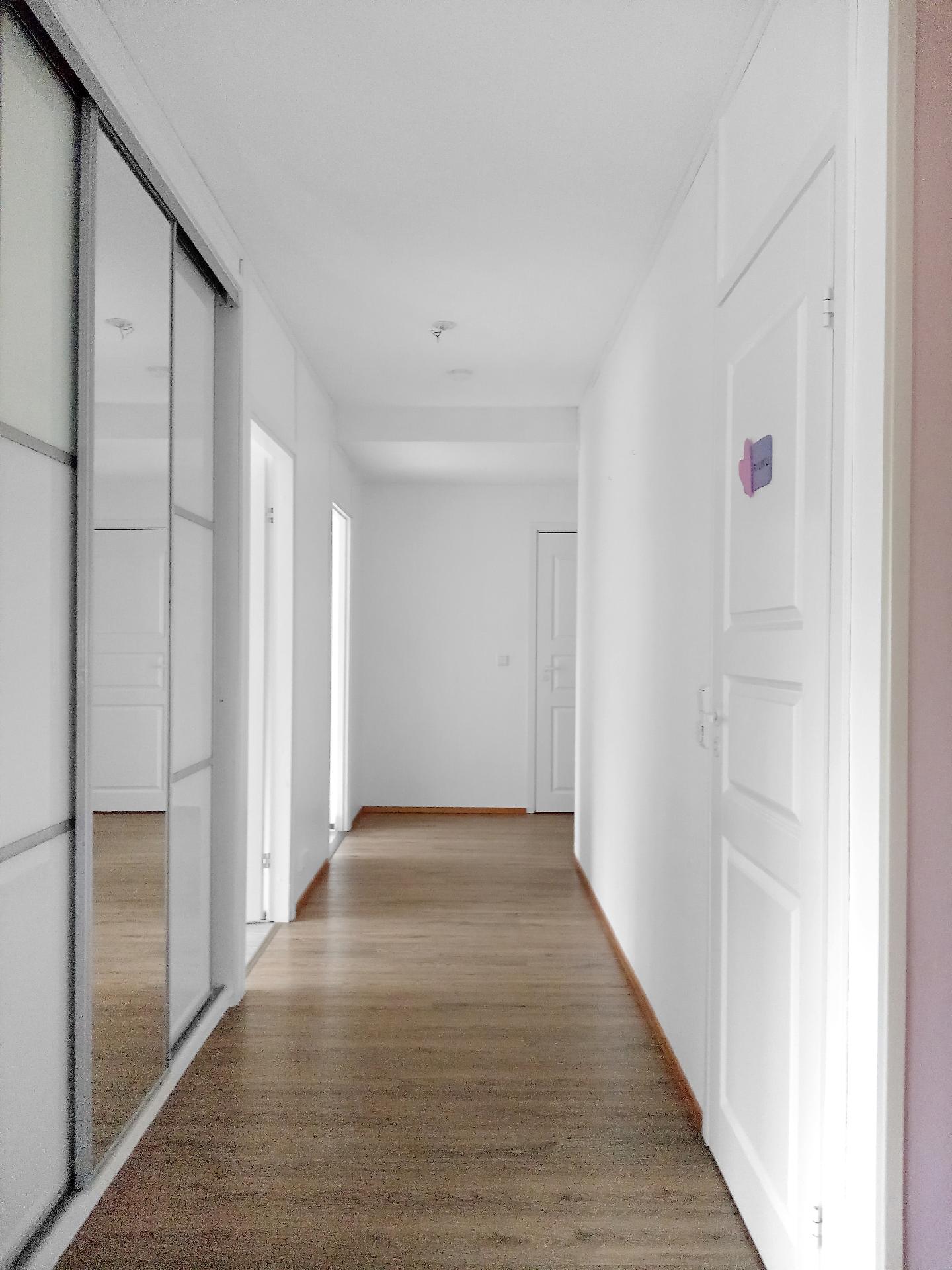 Eteiskäytävä. Vasemmalla liukuovikaapisto, oikealla ovi kylpyhuoneeseen