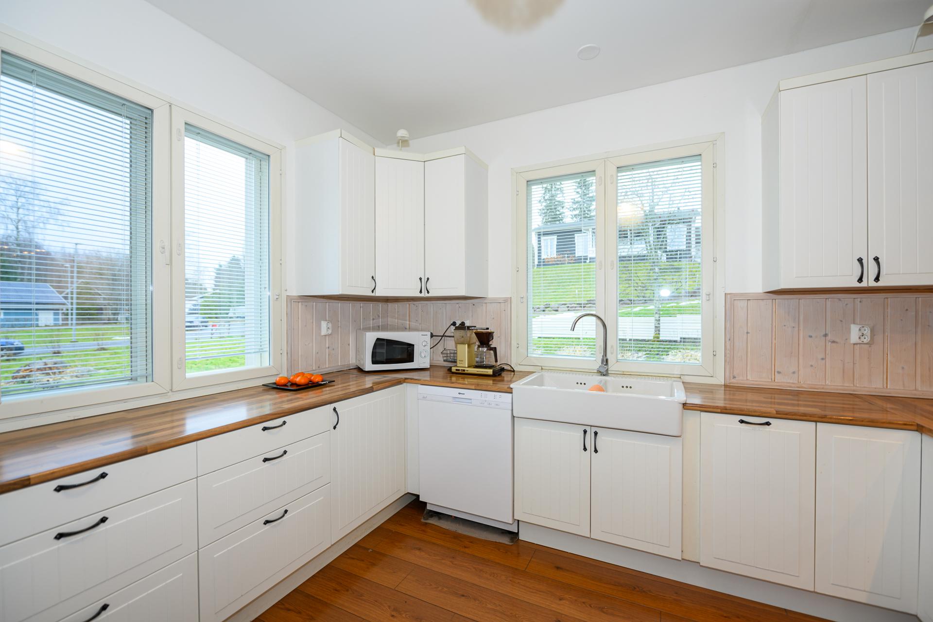 Keittiö on vaaleasävyinen ja siinä hyvin kaapistoja ja tasoja.