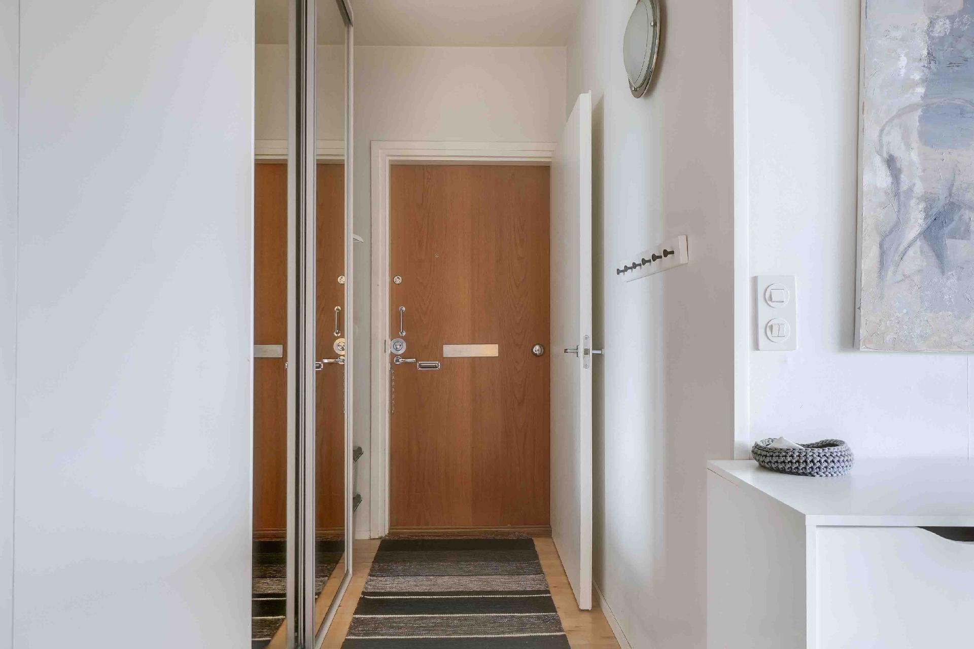 Kylpyhuoneen edestä näkymää ulko-ovelle, vasemmalla kaapistot ulkovaatteille.