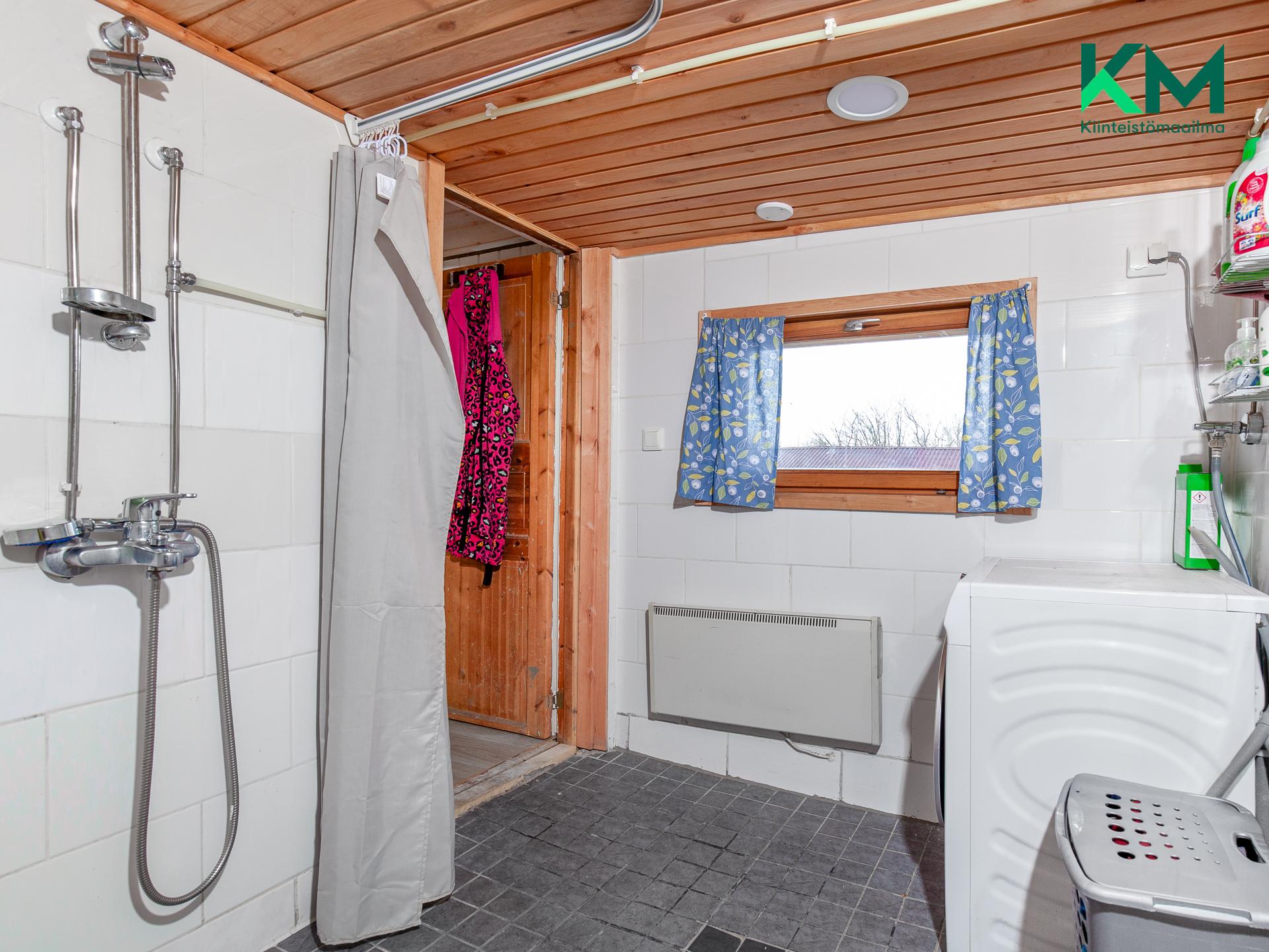 Kylpyhuoneessa on ikkuna, oikealla paikka pesukoneelle