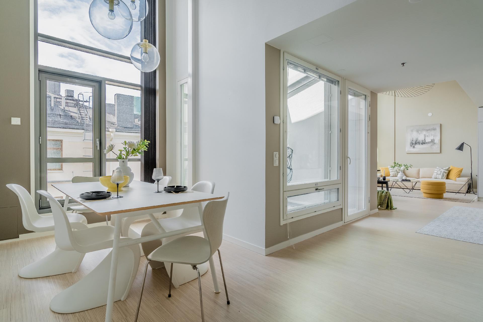 Ruokailutila on myös kahden kerroksen korkuinen. Sen iso ikkuna on lämmitettävissä selektiivilasissa olevien sähkövastusten avulla, kuten olohuoneen isot ikkunatkin.